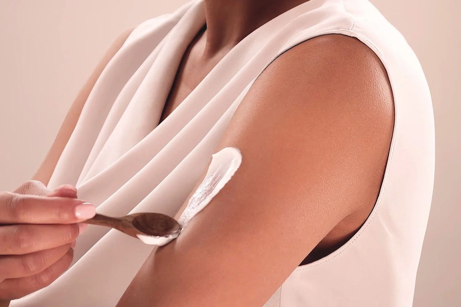 A woman applying the Eminence Organics Ashwagandha Ultra-Rich Restorative Cream to her arm