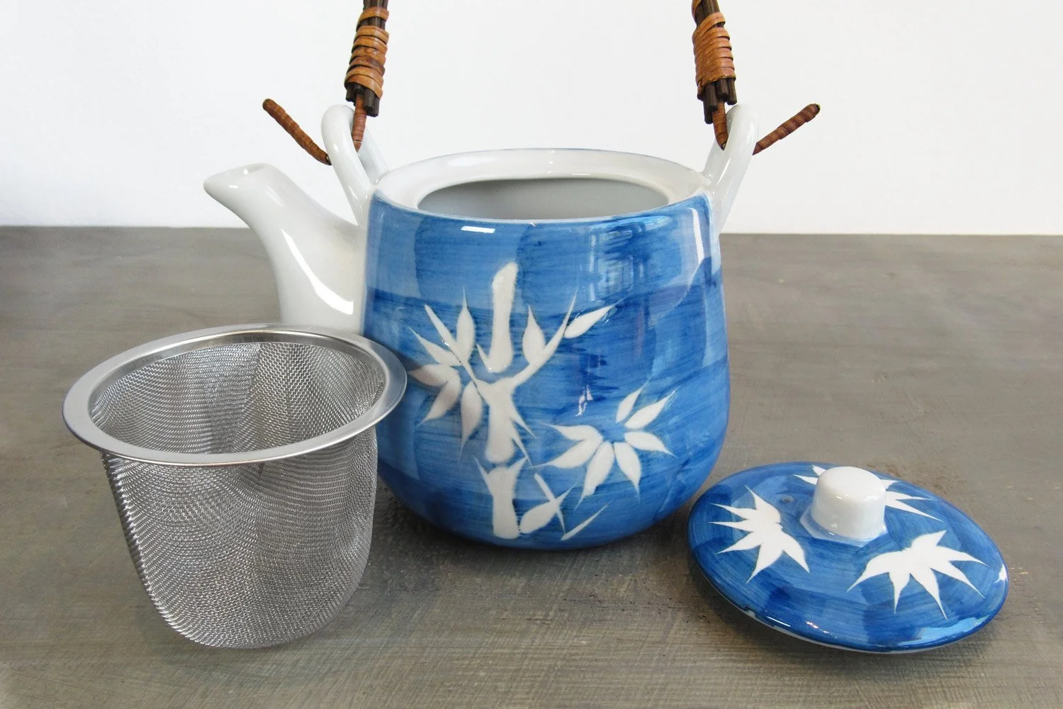 blue & white bamboo pattern teapot with a rattan handle and stainless steel strainer