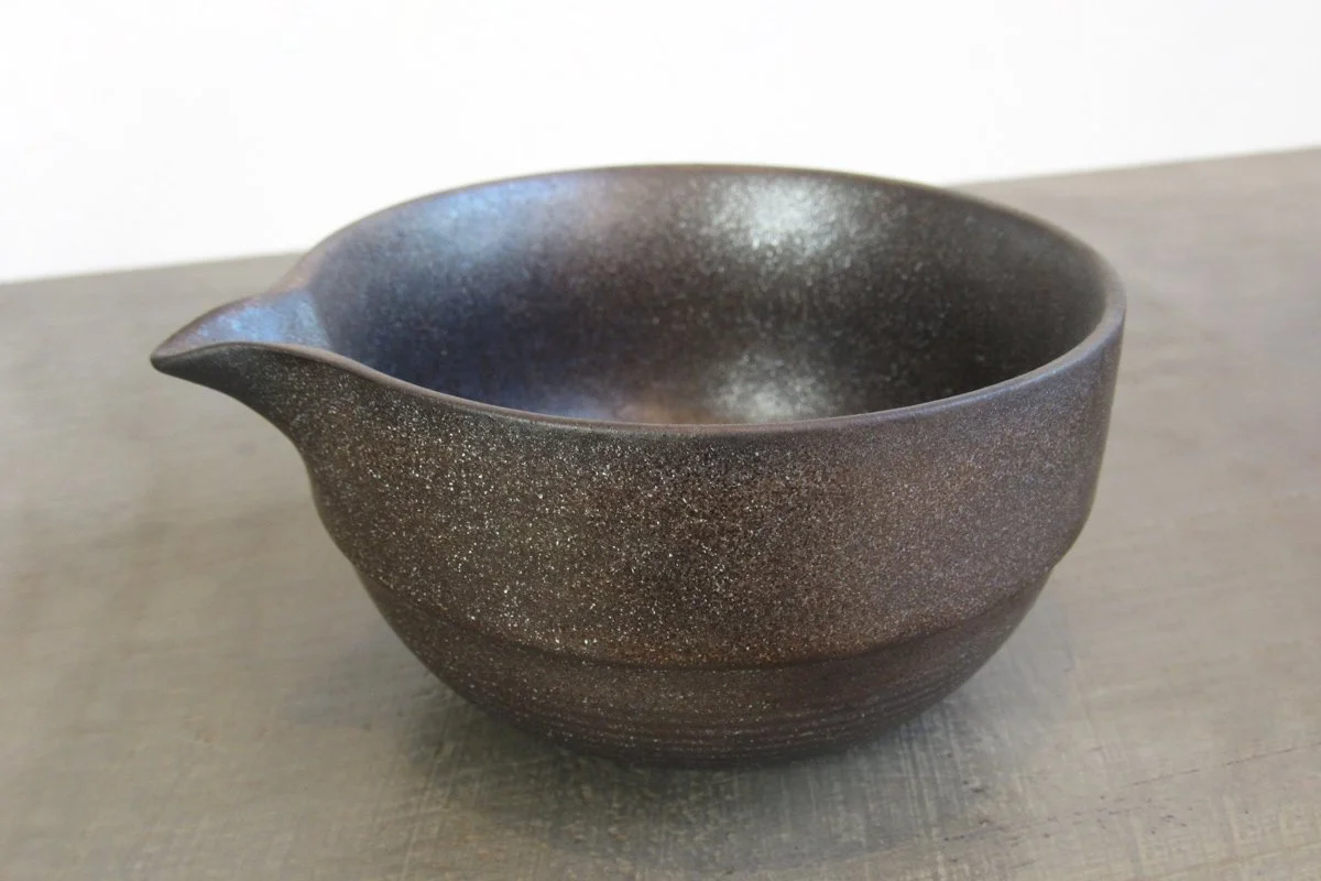 Dark-glazed matcha bowl with a metallic shimmer and pouring spout