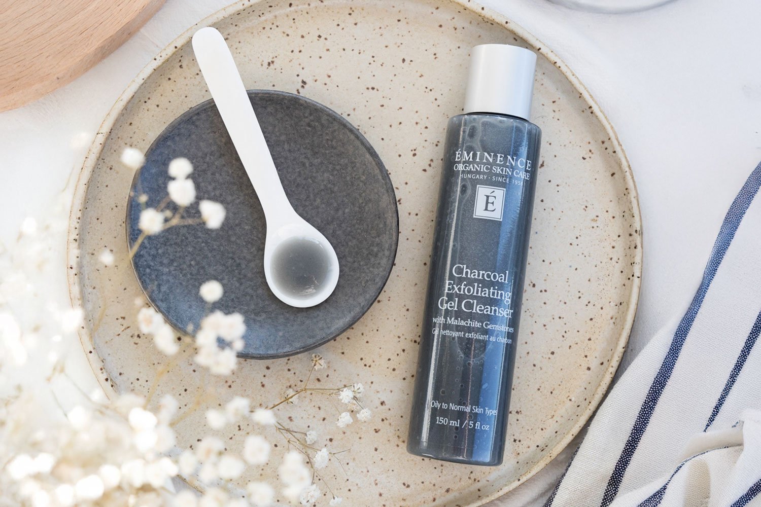 Top-down view of the Charcoal Exfoliating Gel Cleanser bottle next to a swatch