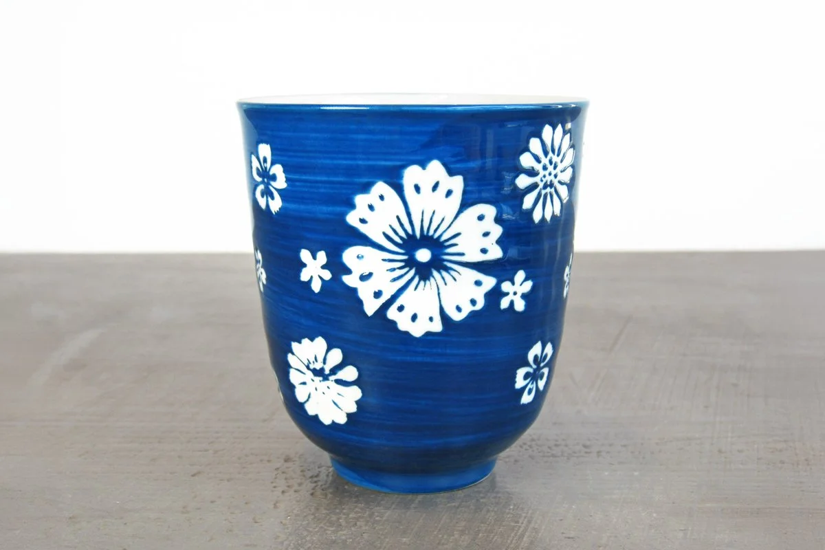 close up of blue glazed teacup with white flowers