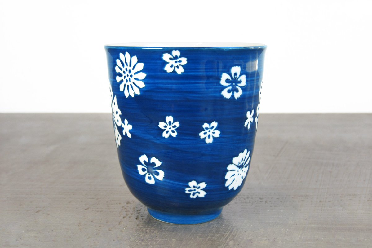 close up of blue glazed teacup with white flowers
