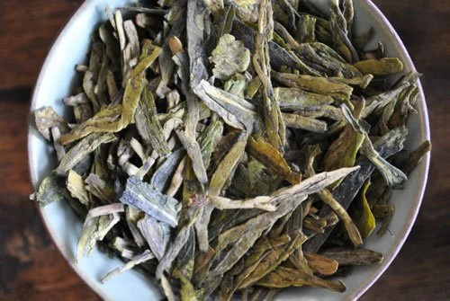 loose green tea leaves in tea bowl