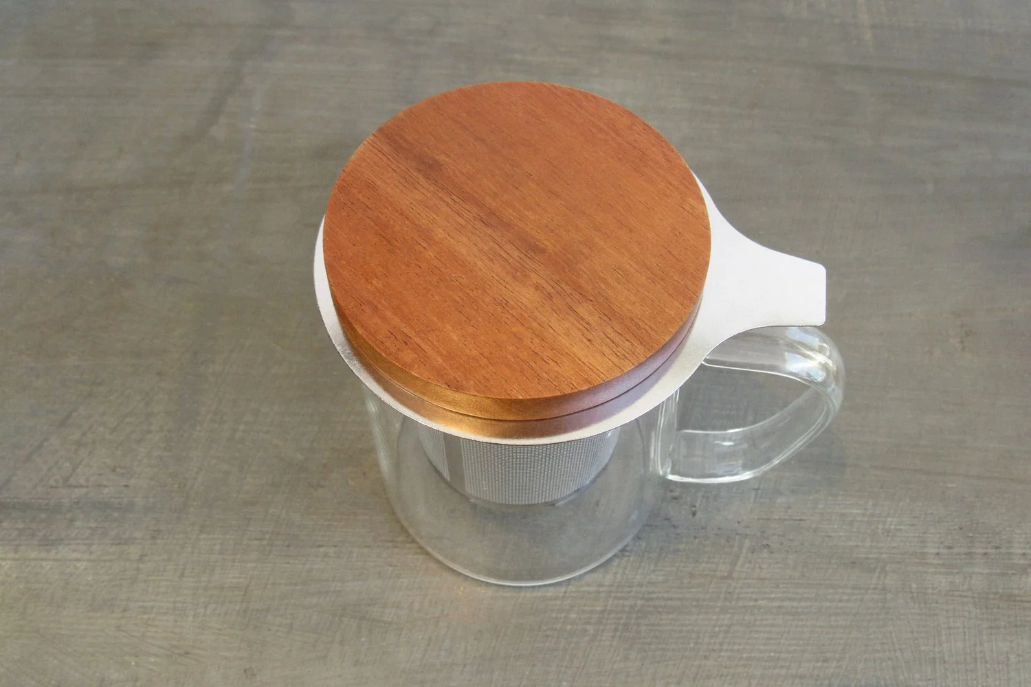 Top-down view of a glass tea mug with a wooden lid