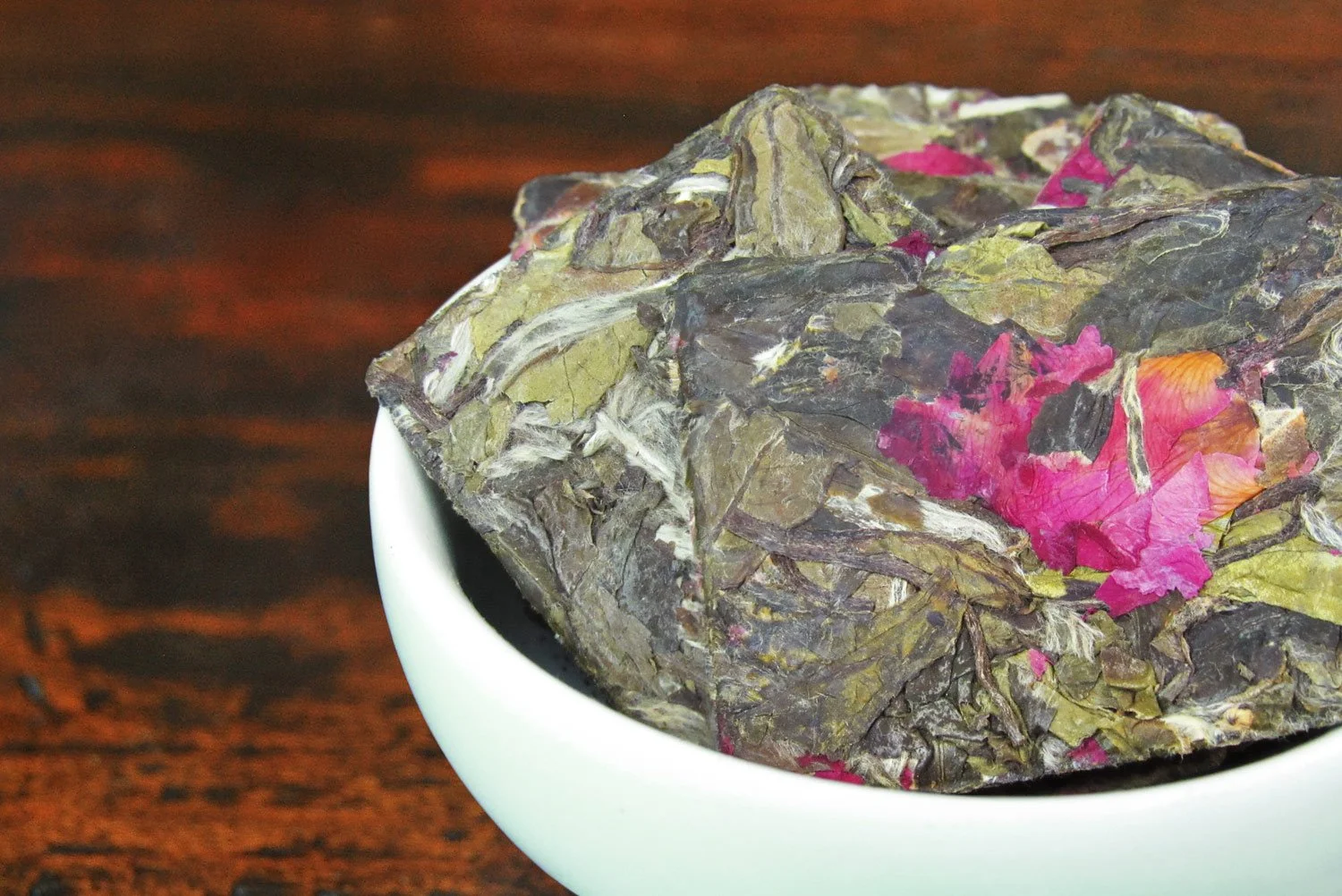 rectangular white tea cakes with rose petals in a white bowl
