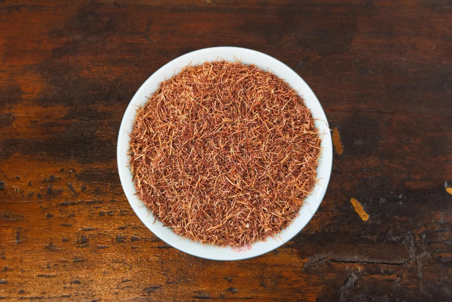 Top-down view of cornsilk tea in a white tea bowl