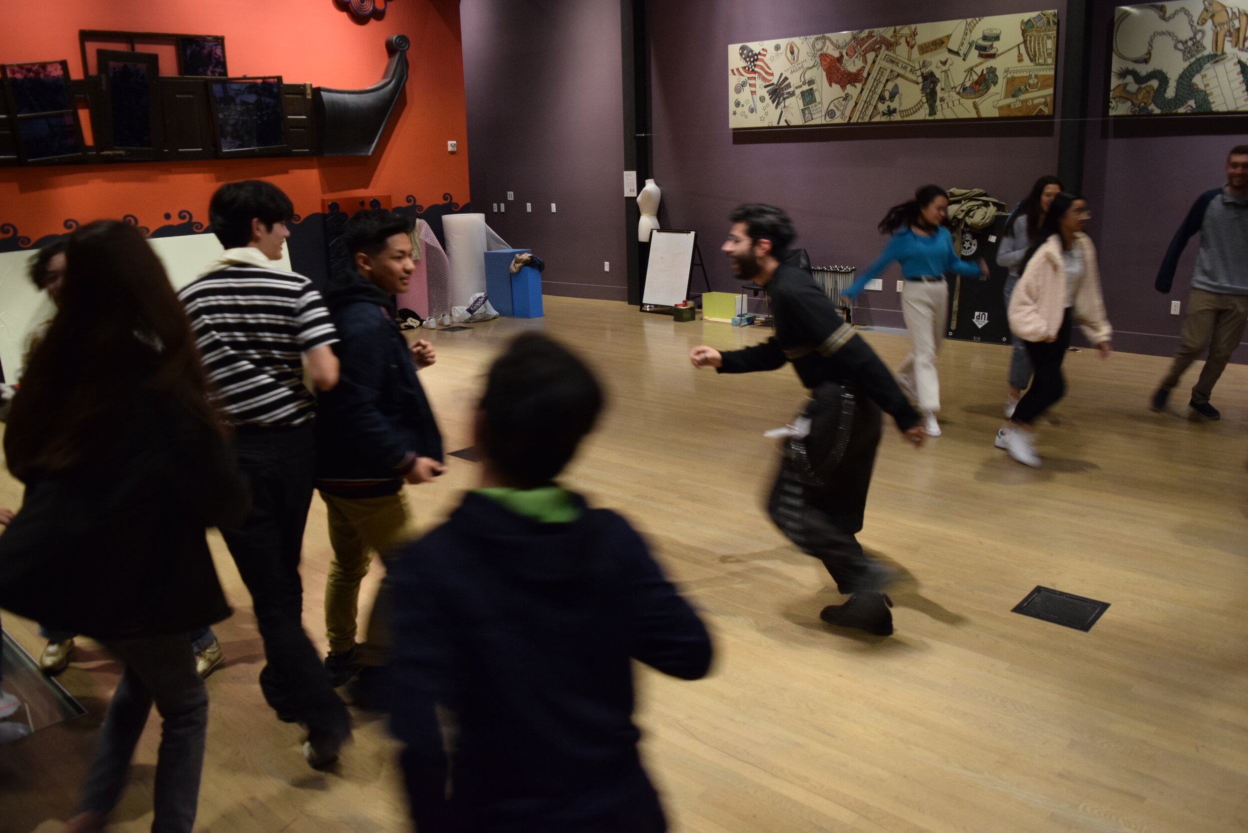  Students participate in a movement exercise, paired up and maintaining eye contact with one another while constantly in motion throughout the Community Hall.  
