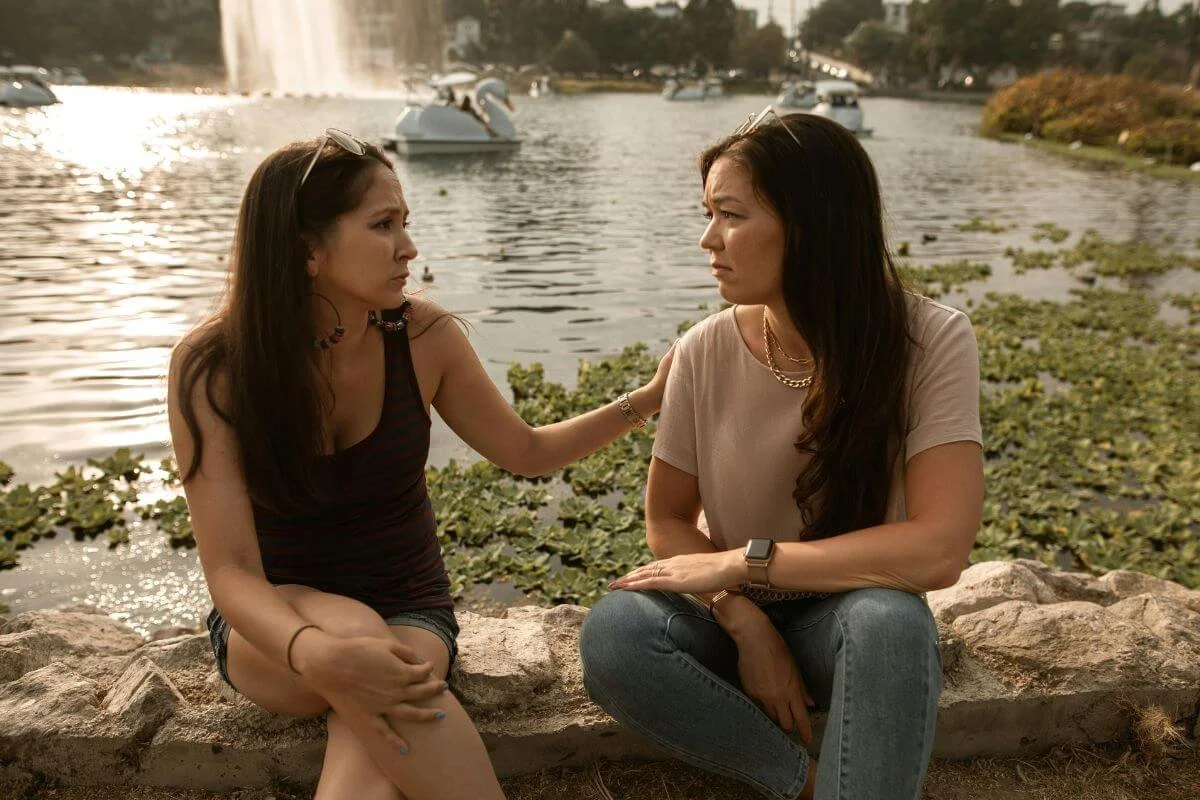 Image of two women sitting and one touching the shoulder of the other. If you are struggling with support your autistic partner get them the help they need with neurodivergent therapy in middlesex, nj