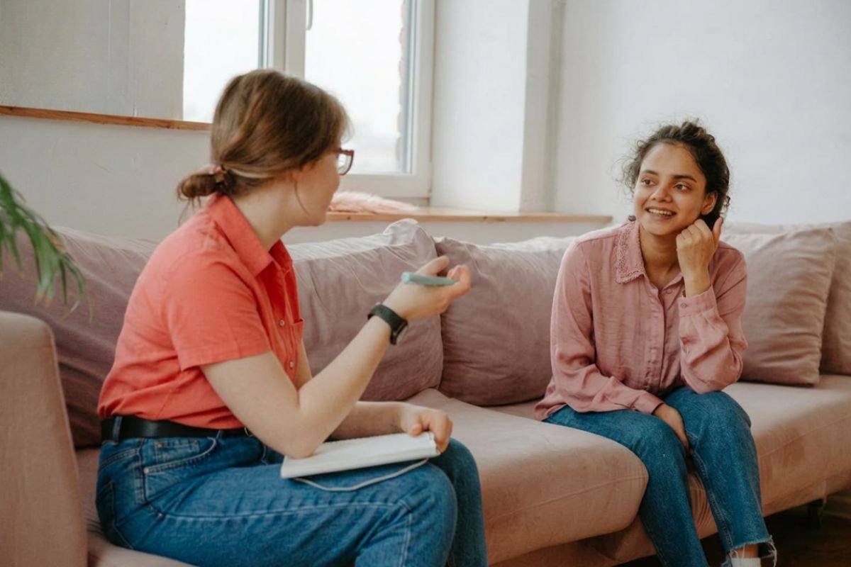 A therapist and client sitting together on a couch having a calm conversation representing what to expect during an ADHD or autism evaluation at True Reflections MHS in Middlesex New Jersey