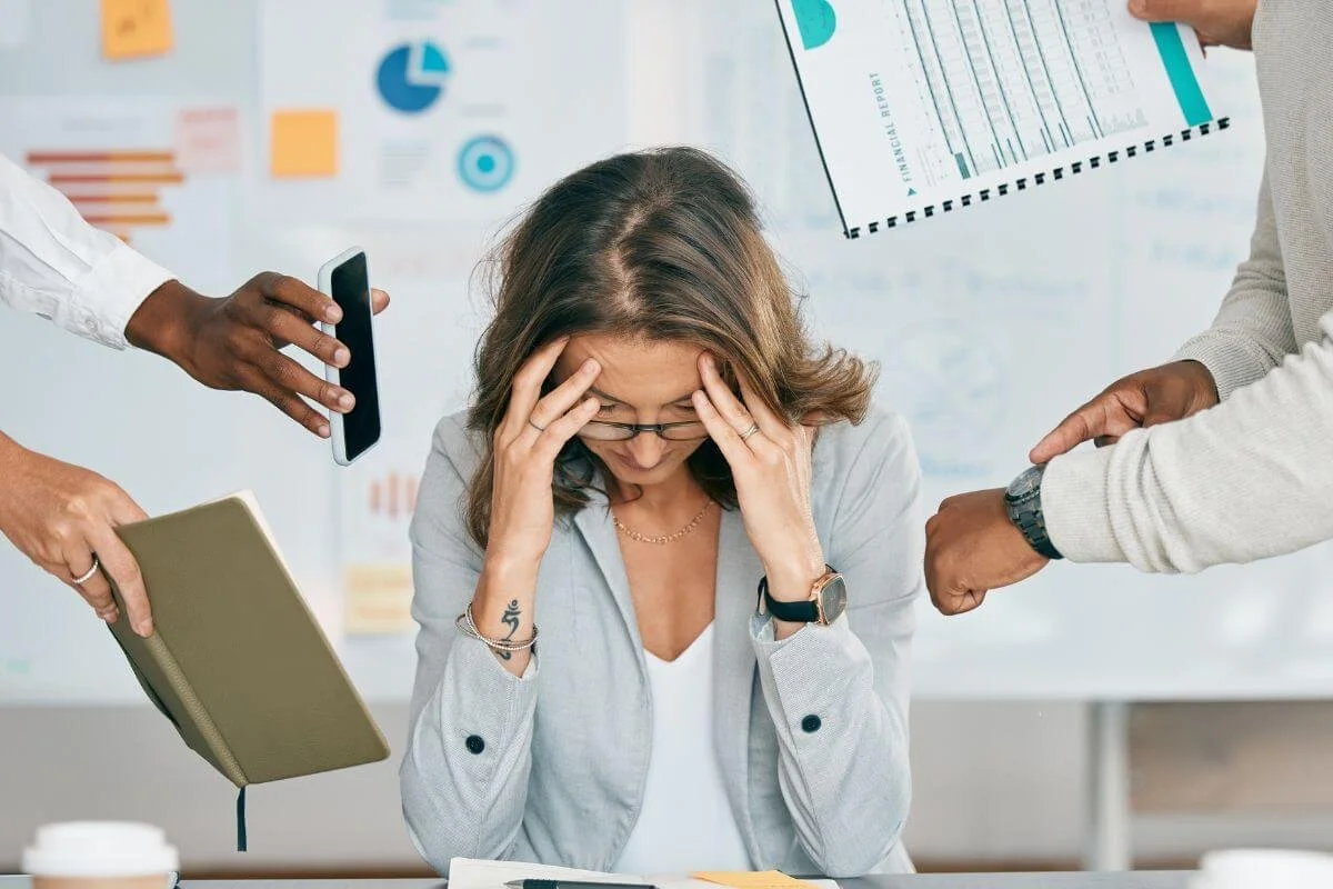 image of woman with hands on head overwhelmed at work. Discover your neurodivergence and get the support you need to manage you ADHD symptoms with ADHD testing in Middlesex, NJ