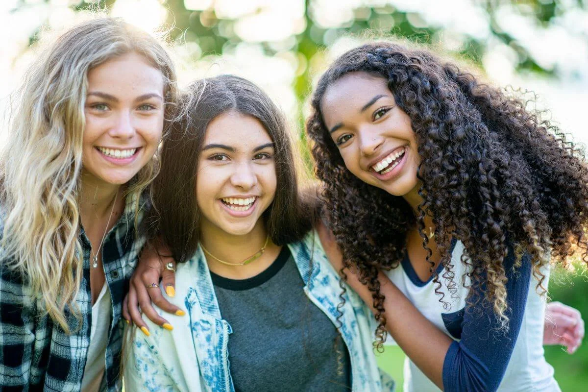 Three teenage girls standing together representing the specialized neurodiversity affirming ADHD and Autism evaluations for girls at True Reflections MHS in Middlesex NJ