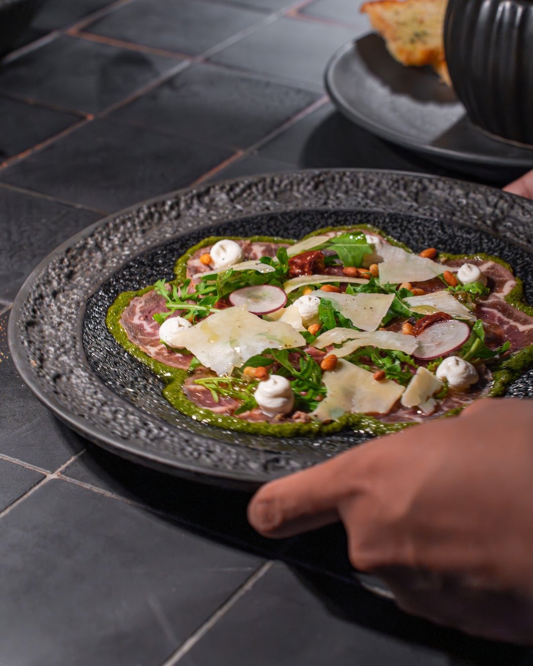 Sometimes the simplest dishes leave the biggest impression.

The Wagyu Tenderloin Carpaccio at Embers balances rich marbling with bright citrus notes, peppery rucola, nutty parmesan, and fragrant basil pesto. Light yet indulgent, it's the perfect beg
