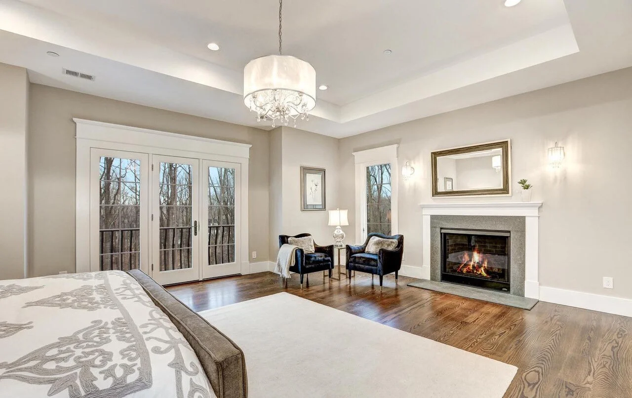 A fireplace is in a master bedroom is a luxury! Placing a sofa directly in front of the fireplace might have been the obvious choice, but would have limited the view from the bed. We placed chairs to the side to demonstrate how purchasers can enjoy …