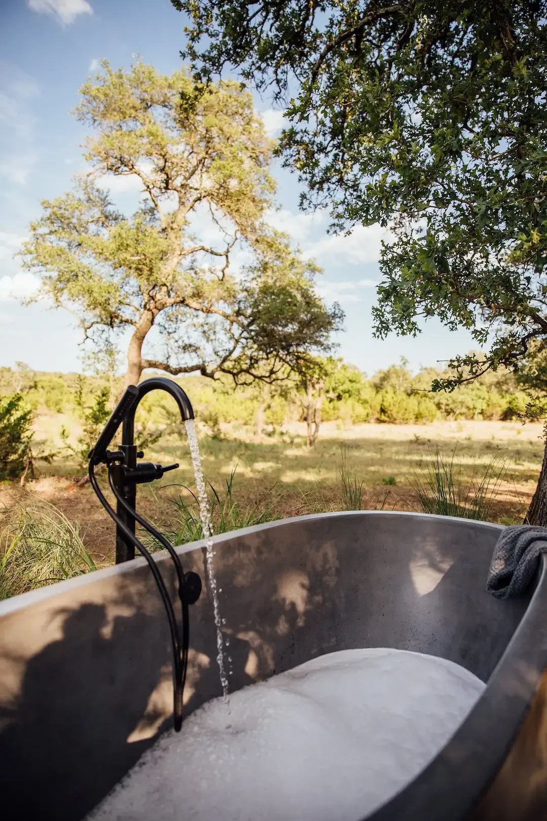 nowhere-hammock-lodge-outdoor-tub-filling-with-water.webp