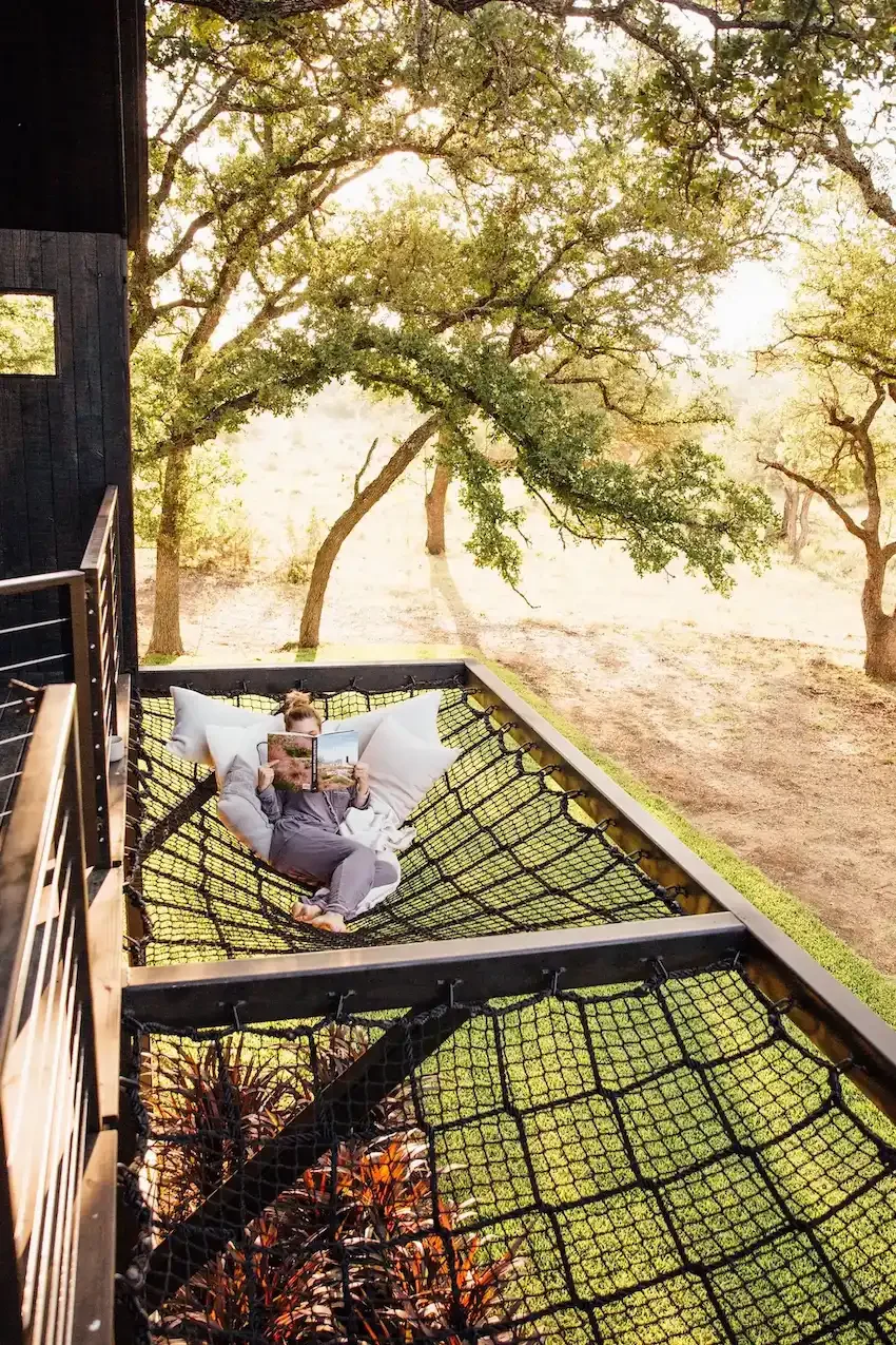 nowhere-hammock-lodge-guest-reading-on-net-bed.webp