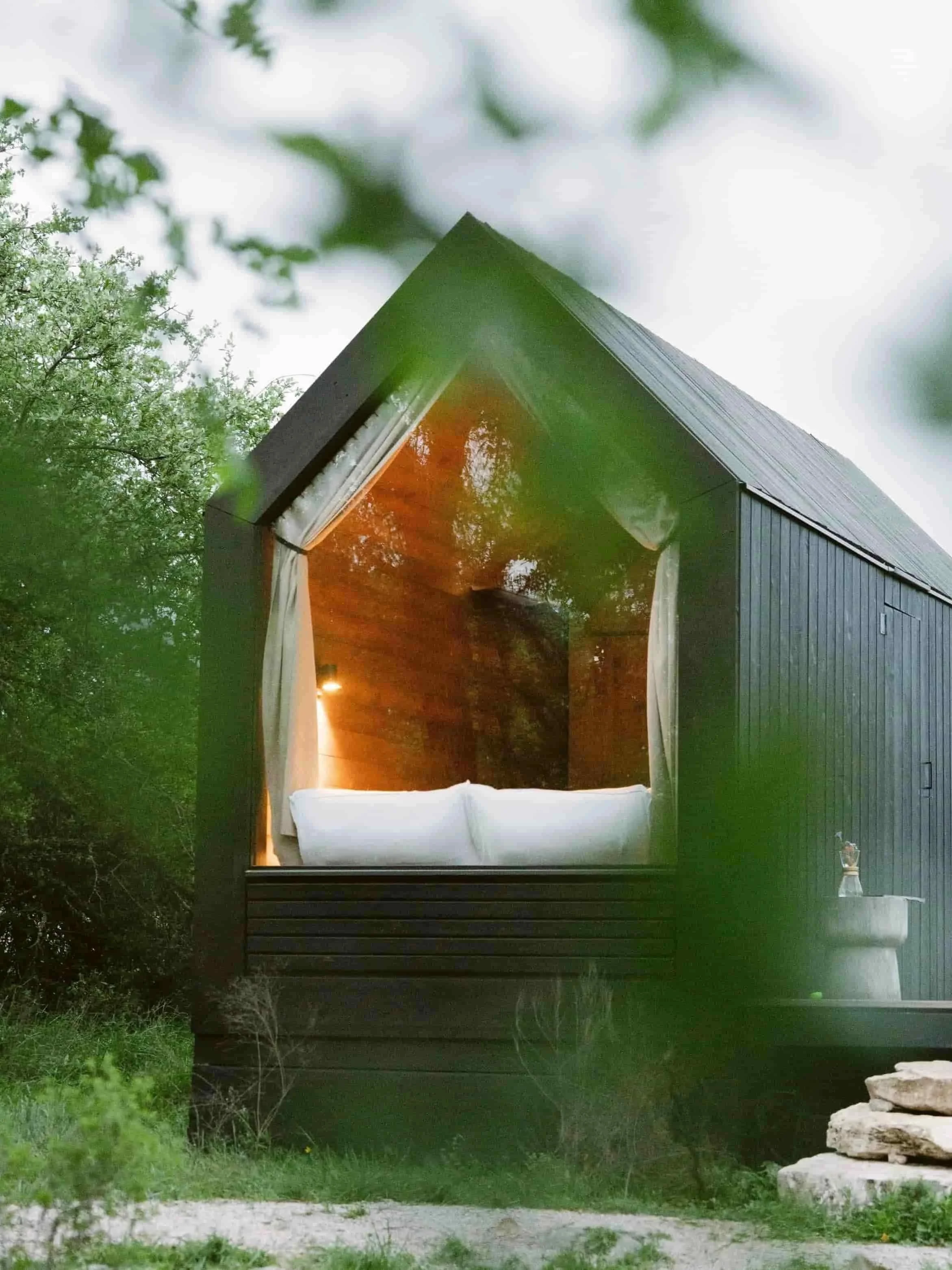Cozy tiny cabin bedroom with forest view at NowHere TX digital detox retreat near Austin Texas