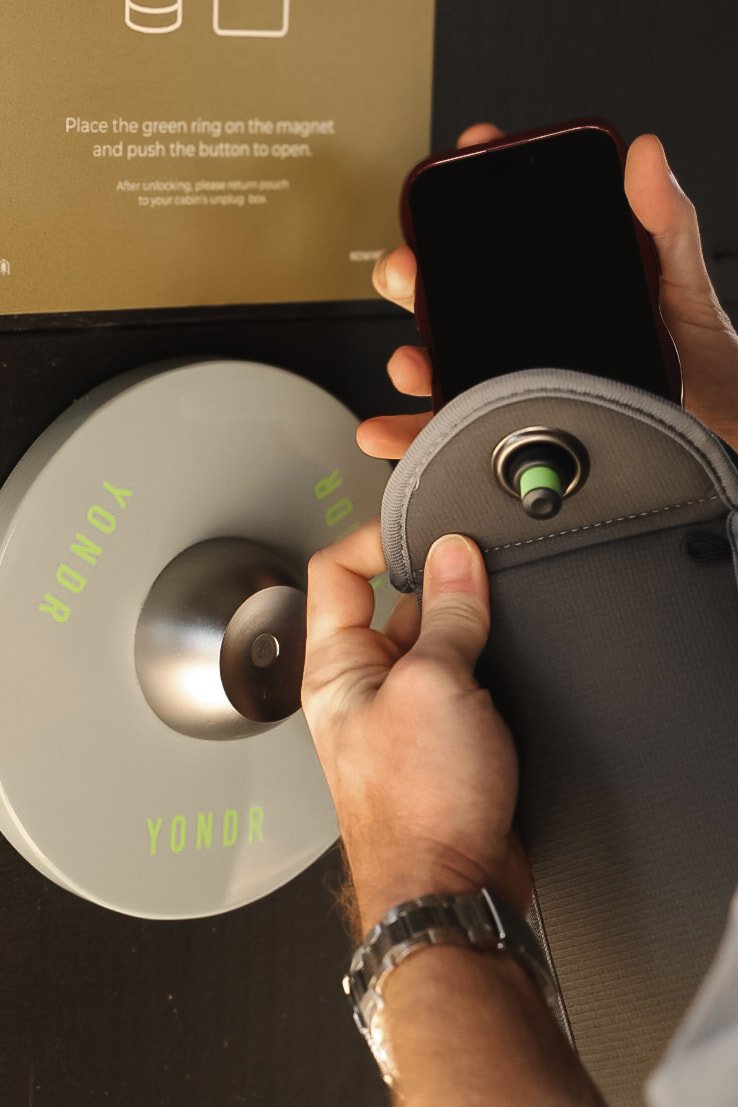 Placing phone into Yondr pouch for digital detox stay