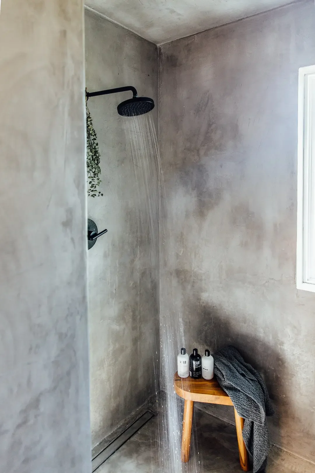 nowhere-hammock-lodge-concrete-rainfall-shower-wooden-stool.webp