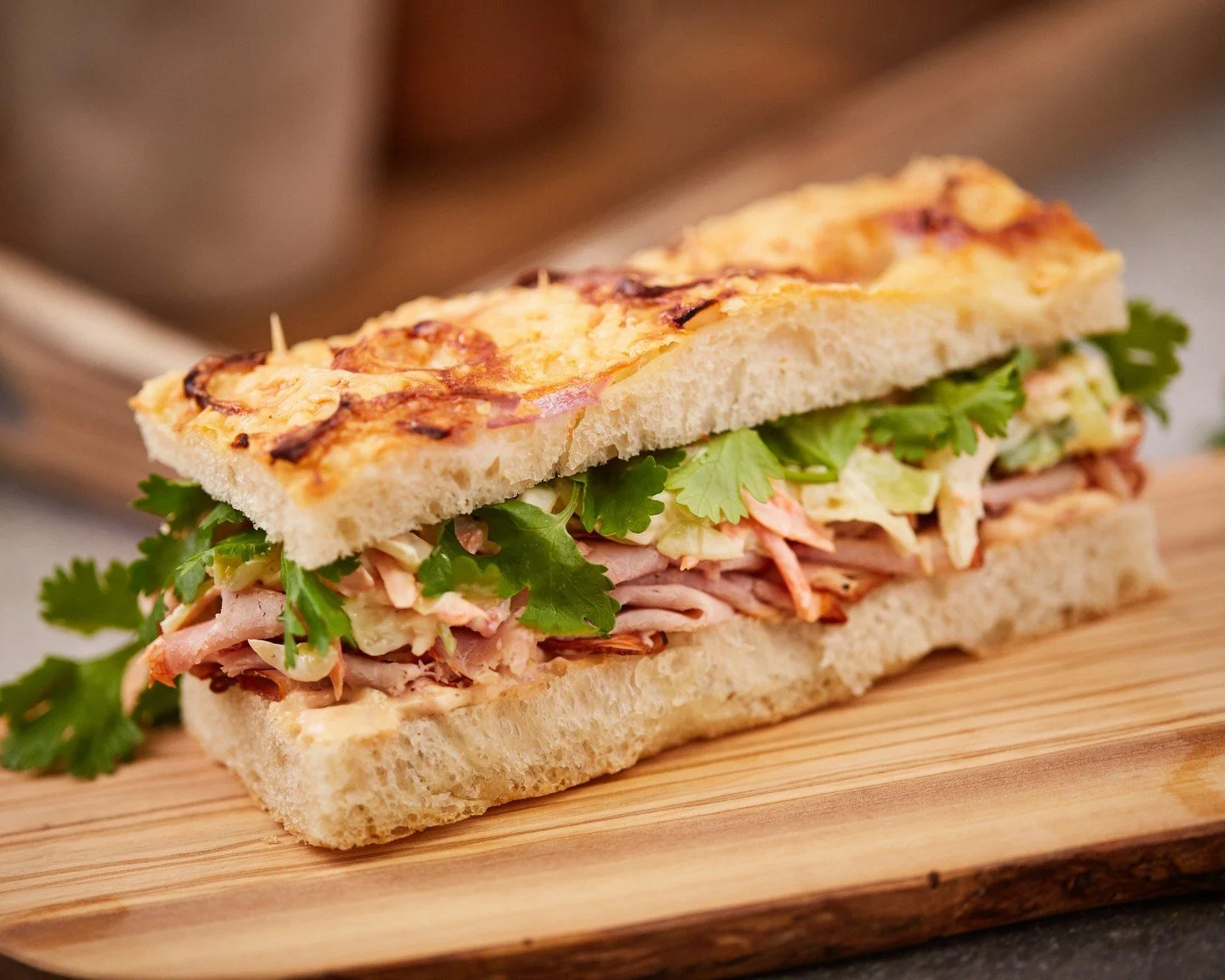 For lunch today, stop in and enjoy our Smoked Pork Sandwich. We pair our housemade Parmesan-red onion focaccia with tender smoked pork, then add crisp coleslaw, a touch of cilantro, and chipotle aioli for an extra smokey flavor.