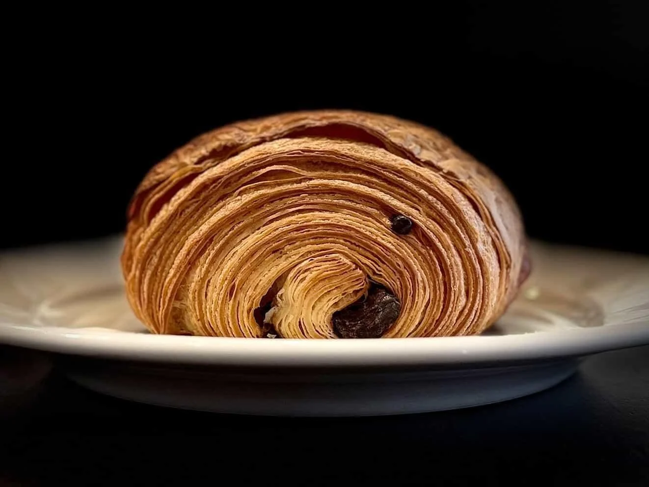 Buttery, flaky layers wrapped around rich dark chocolate, our Chocolate Croissant is a classic done right. 🥐

Made in house and baked fresh each morning, it's perfect with a cup of coffee (or all on its own). 
Available in our showcases now!

(📸: @
