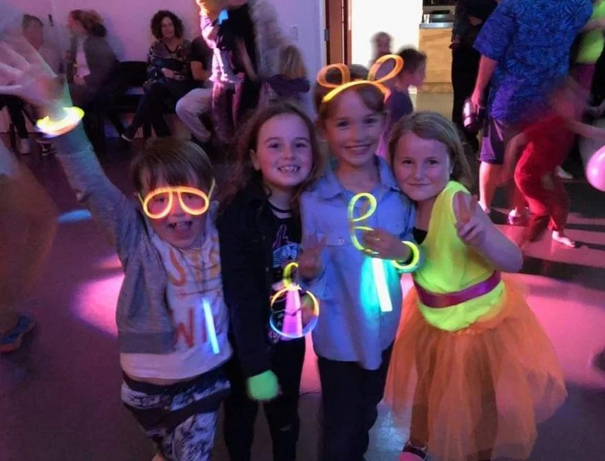 Kids enjoying a neon disco in the hall