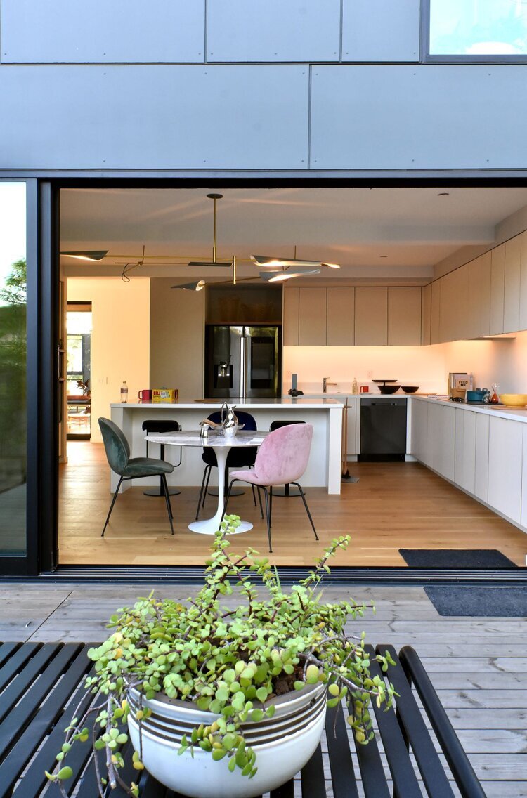 View of the kitchen from the deck in the Connect Homes model, featuring Grenite recycled and prefabricated countertops in the kitchen.