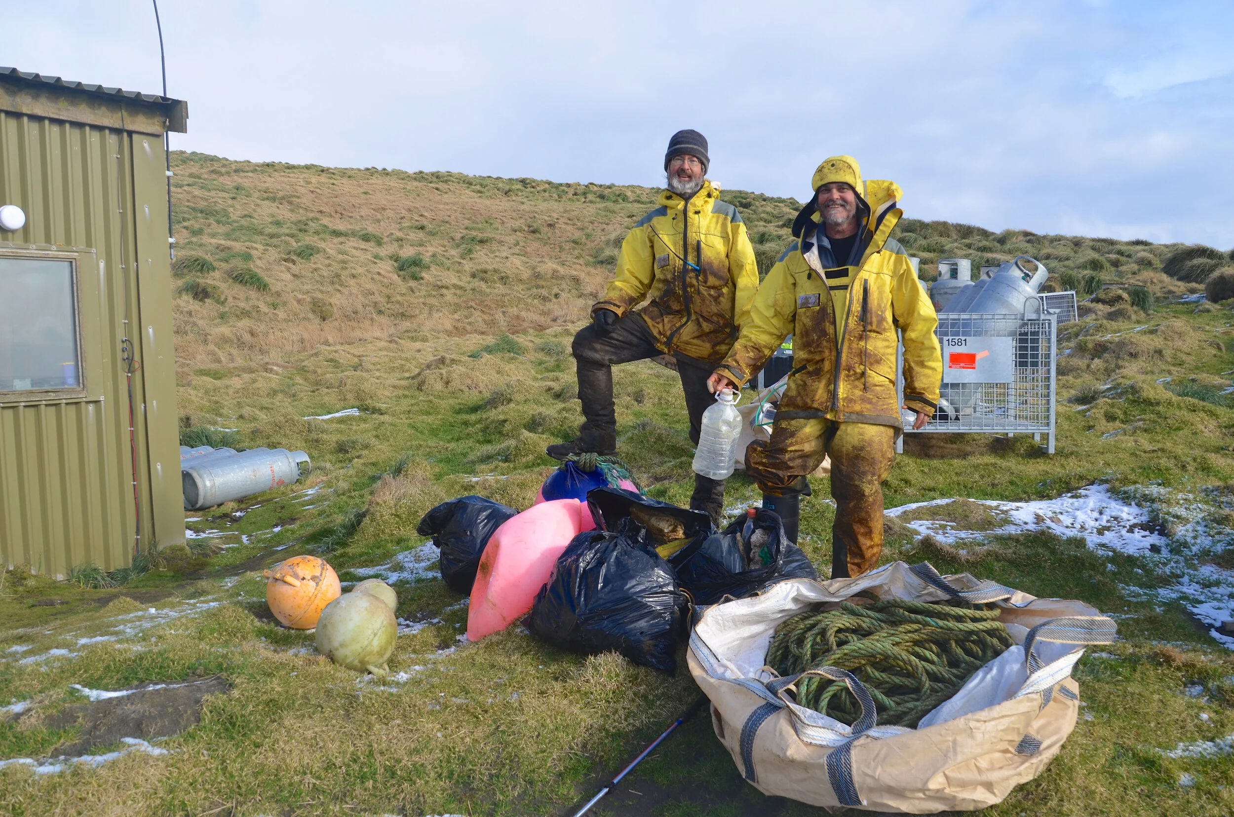 M183 - Clive and Barry at Bauer Bay hut with some marine debris we picked up on the west coast south of Bauer Bay - August 2013
