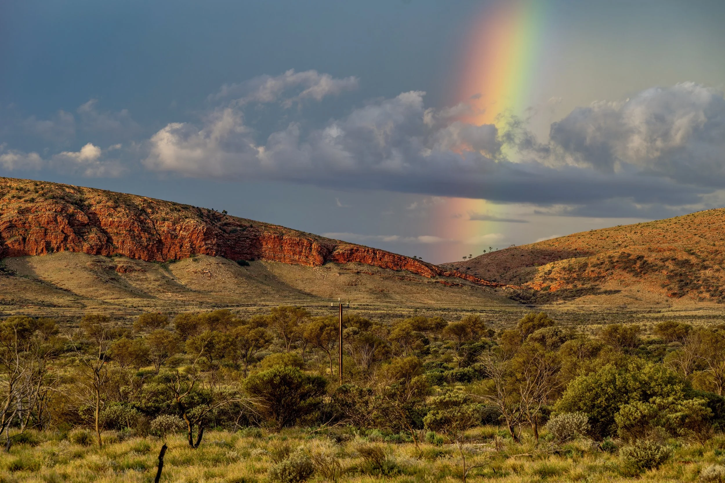 G052- 10th of December 2024 18:49- Golden hour light with showers and a rainbow north of Purli Yurliya (Rawlinson Ranges).
