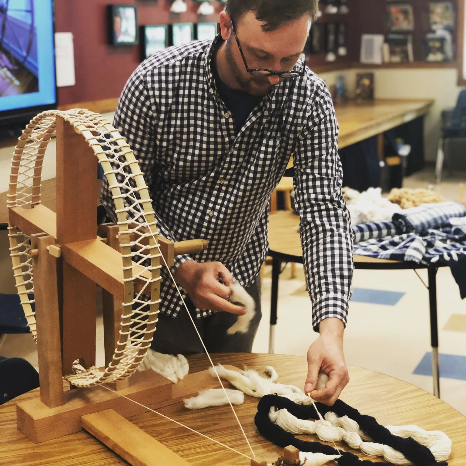 Demonstrating cotton spinning with a Japanese spinning wheel