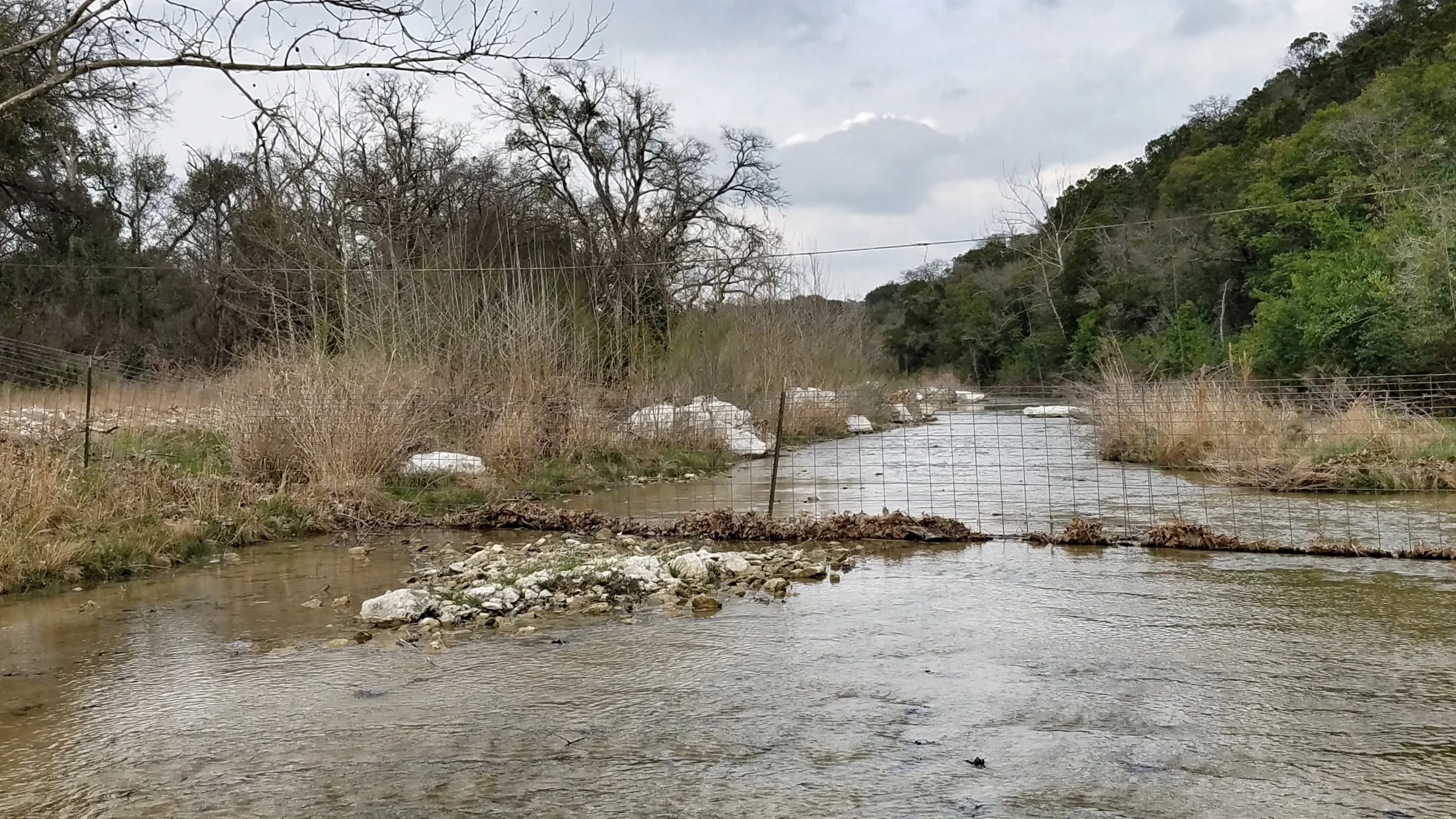 Landowners who own both sides of a stream, or hold title to the stream bed itself, may have a legitimate need to control livestock; however, that doesn’t make this fence across a navigable stream legal.
