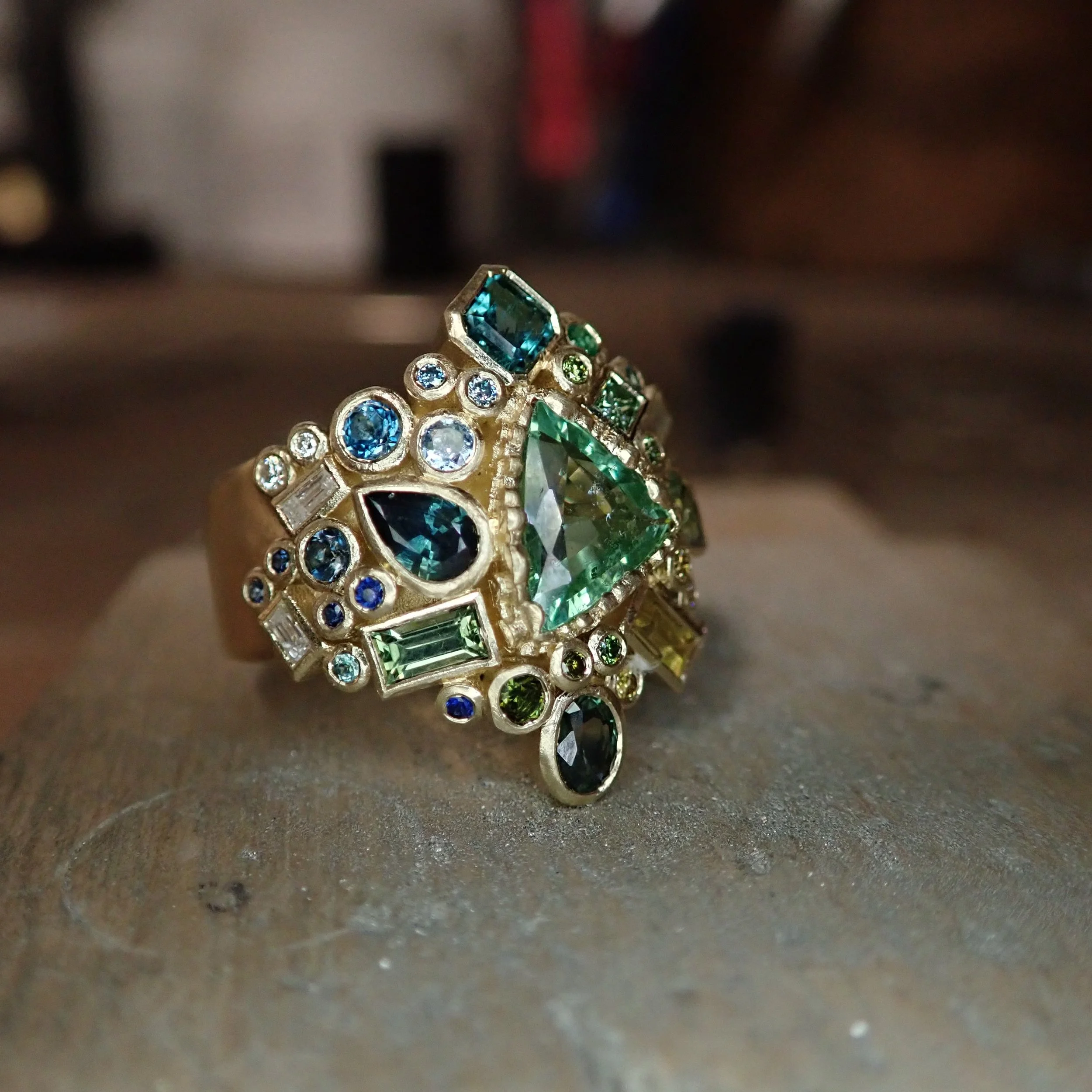 I love making rings like this - building up layers of colour, shape and texture until it feels balanced from every angle. There are deep ocean blues, pale sea greens and flashes of white diamonds scattered throughout, with each cut catching the light