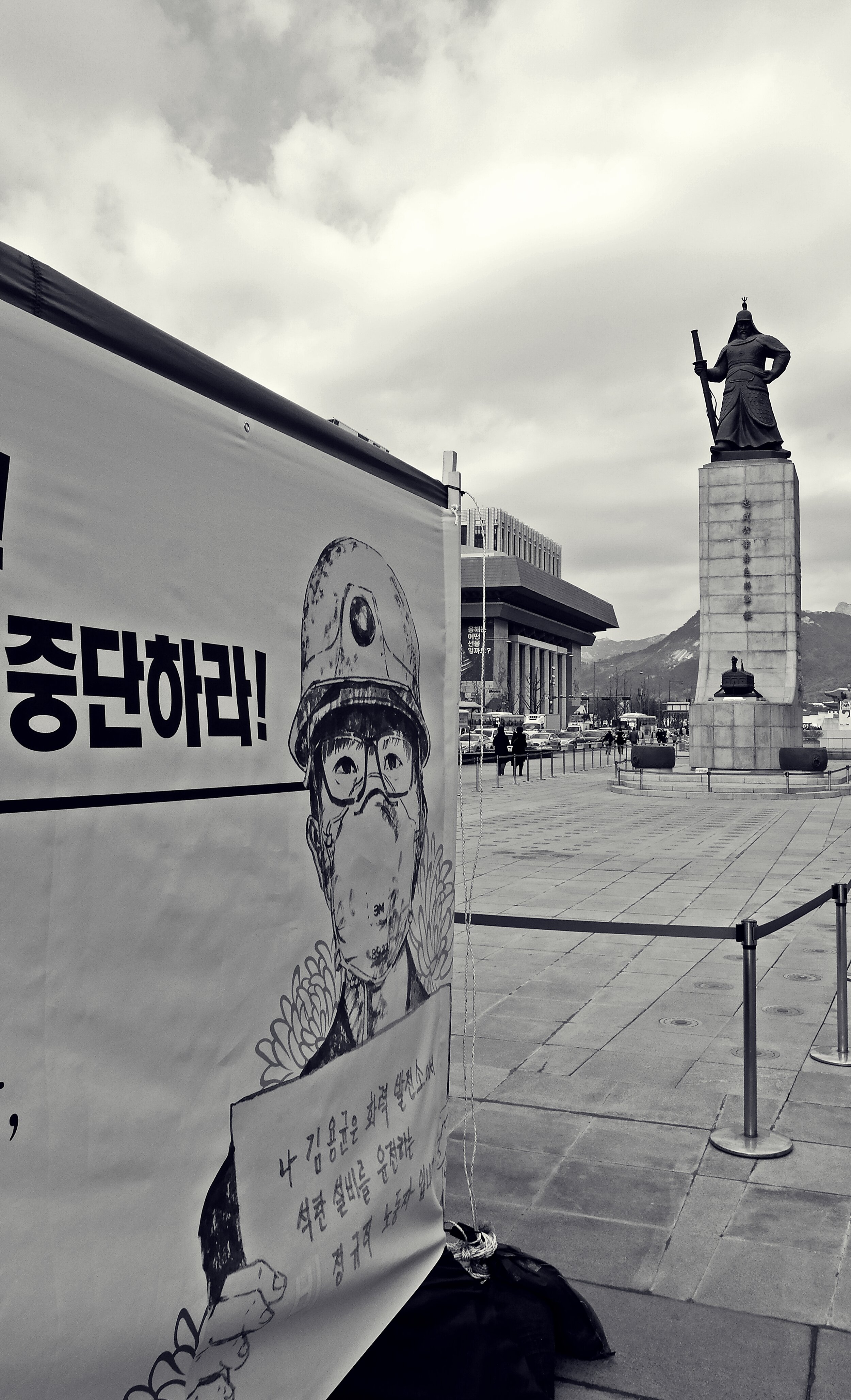  The statue of Admiral Yi Sun-shin stands at Gwanghwamun Square in Seoul, seemingly guarding the young Korean man in the picture. Because of its geographical proximity to the Blue House (the Korean President’s office) and national government offices,
