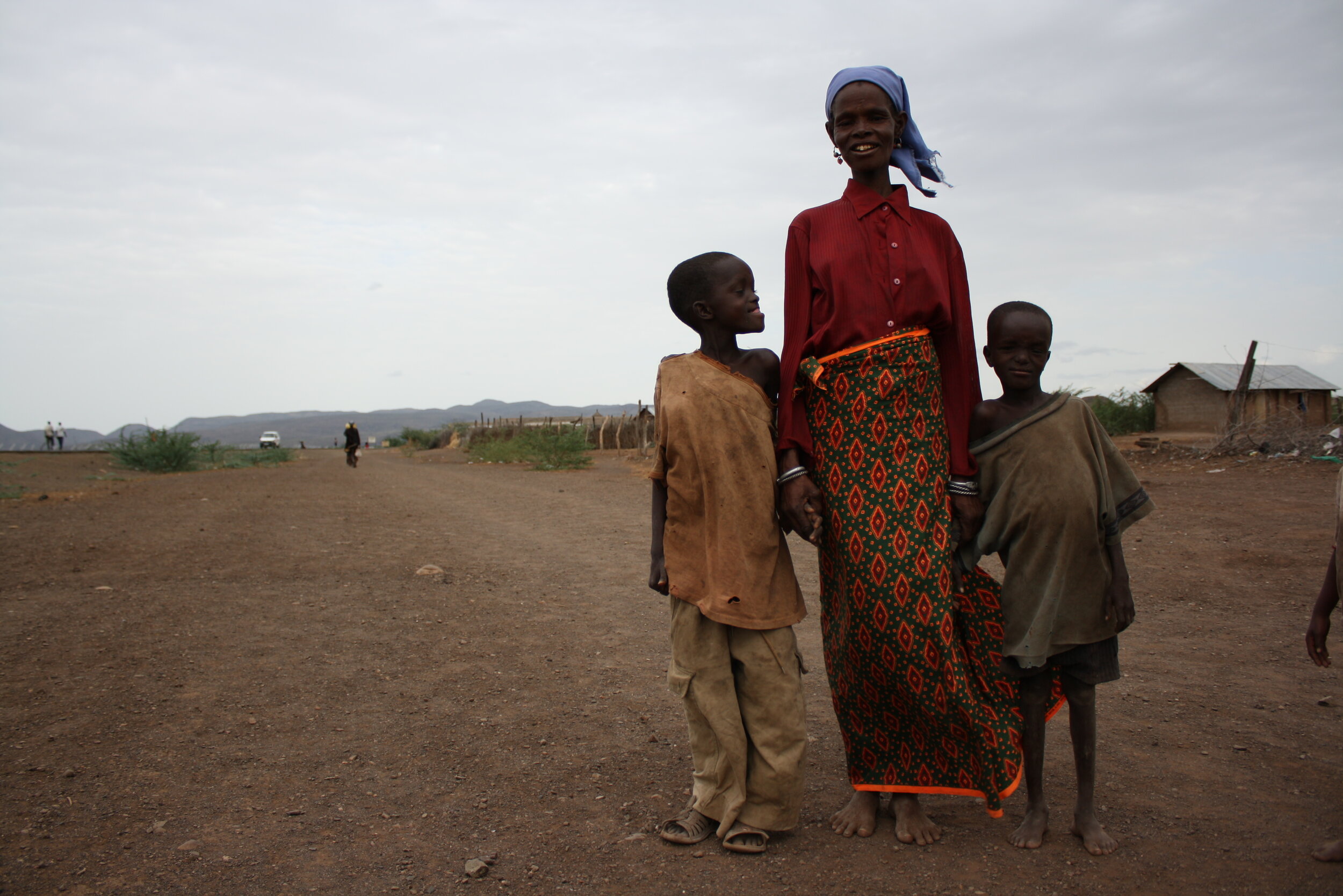  A mother stands with her two sons along Kakuma's only paved road. 