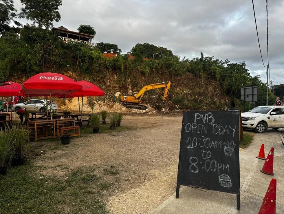   Photo 9 : Port Vila Burger remains open despite a rockslide covering much of the former eating pavilion, patrons now dining across from a large digger that clears the fallen soil. 