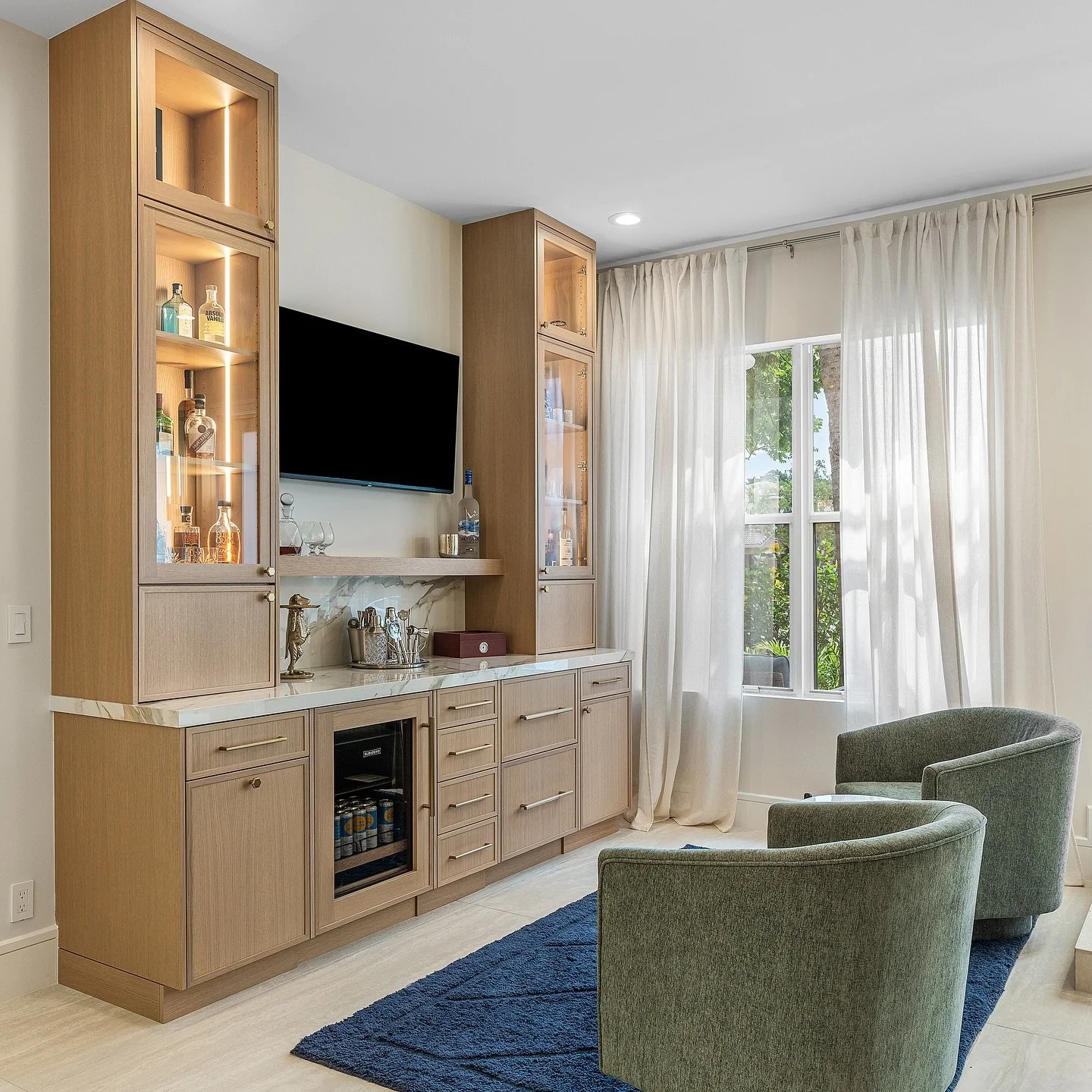 Before ➡️ After: Swipe to see this swanky new bar transformation come to life 🍸✨ Glass cabinetry showcases every bottle and glass like a piece of art, while a sleek Sub-Zero under-counter fridge keeps your favorite spirits perfectly chilled. With cu