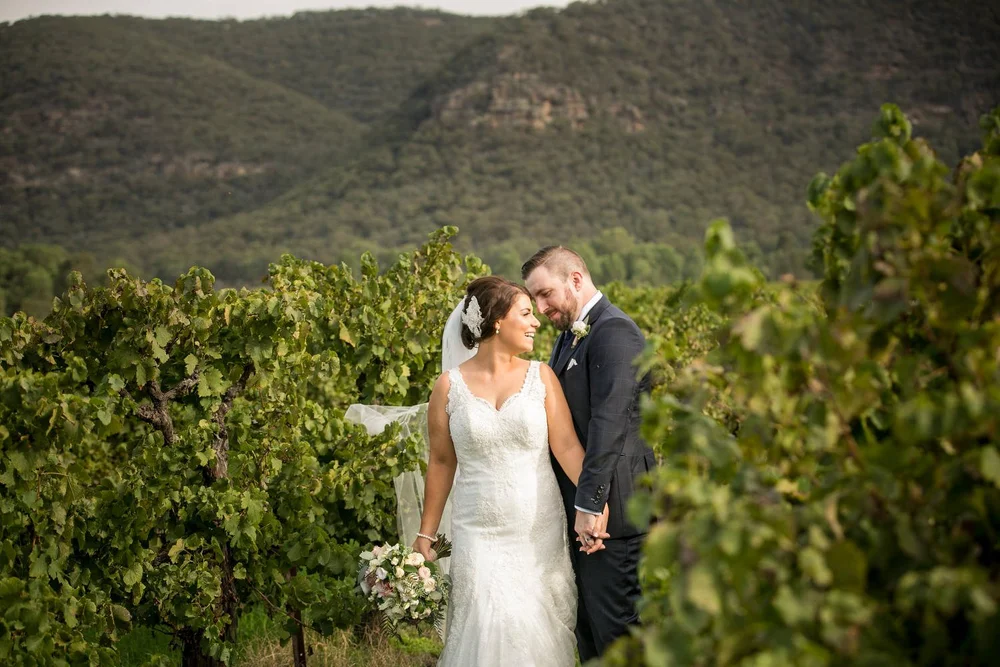 Bride and groom walking through a Hunter Valley vineyard