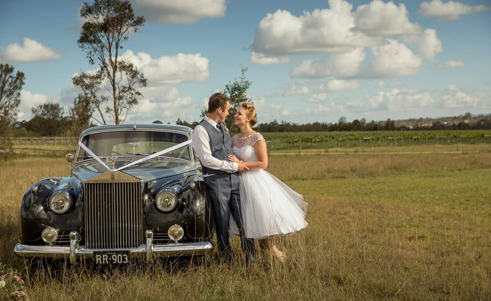 Newlyweds beside a classic wedding car in the Hunter Valley
