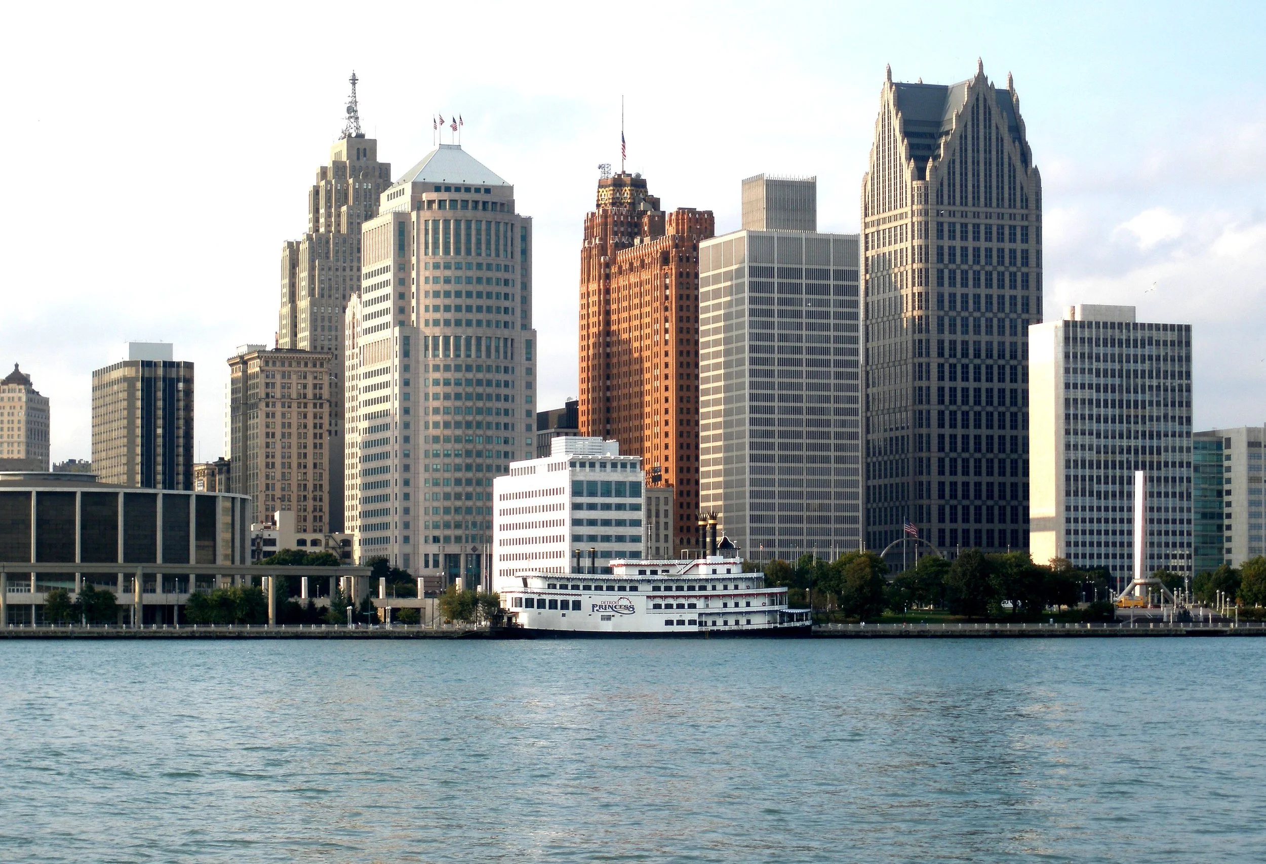It's Just Food LLC | Personal Chef & Catering, serving the Metro Detroit area | City skyline with tall buildings viewed from across a body of water, including the Detroit Princess boat at the waterfront.