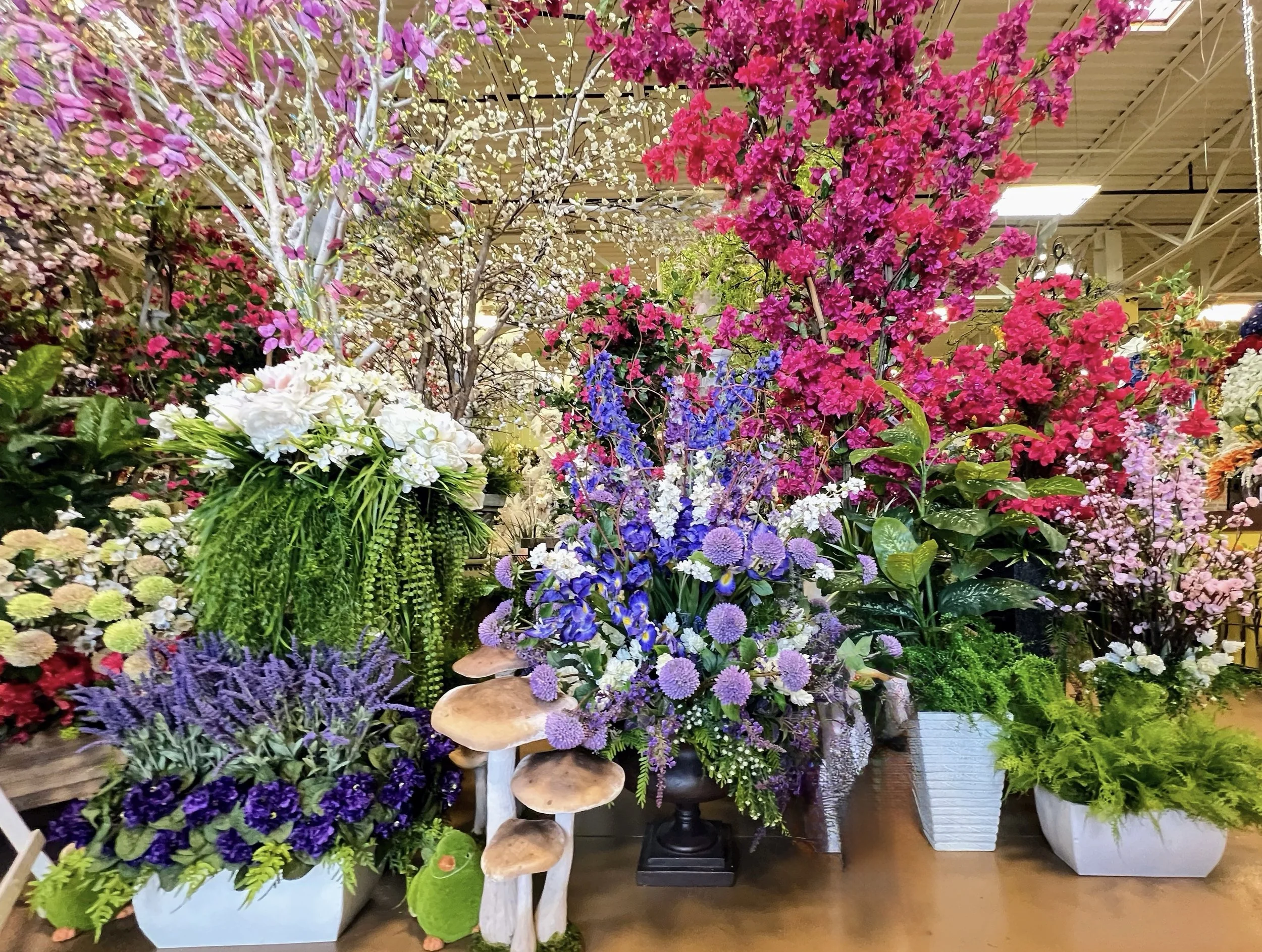 Silk flower showroom display with blossom branches, delphinium, and iris at Arcadia Floral & Home Decor in Houston