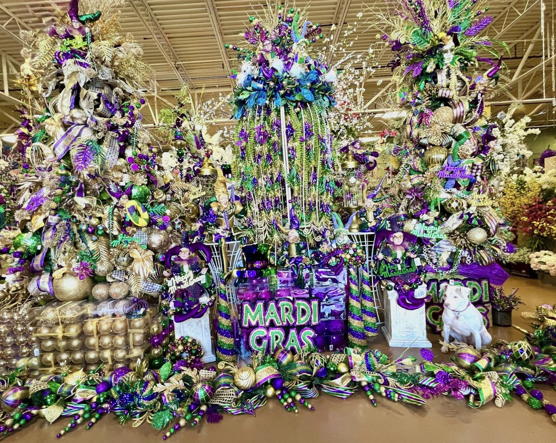 Mardi Gras decorations in Houston featuring purple, green, and gold decorated trees, garland, and ornaments on display at the Arcadia showroom