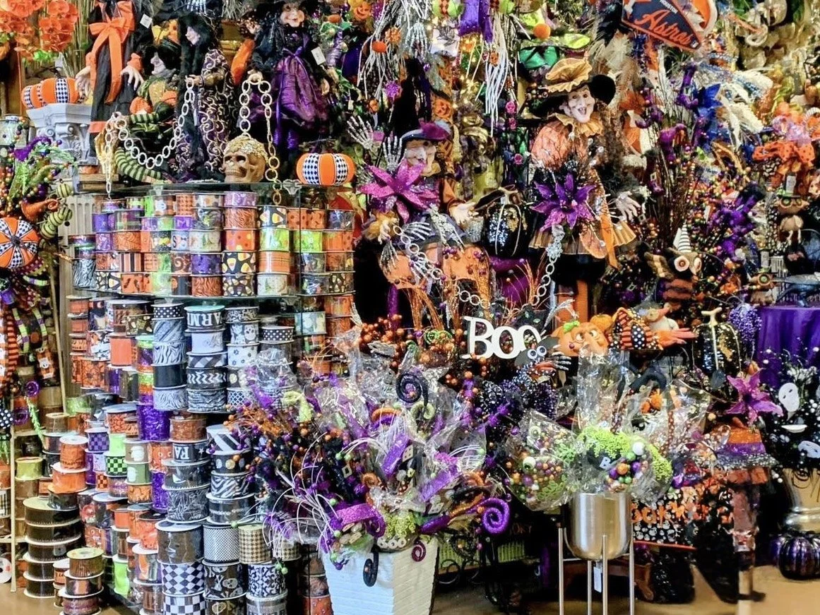 Halloween decorations in Houston featuring witch figures, wreaths, floral picks, and Halloween ribbon on display at the Arcadia showroom