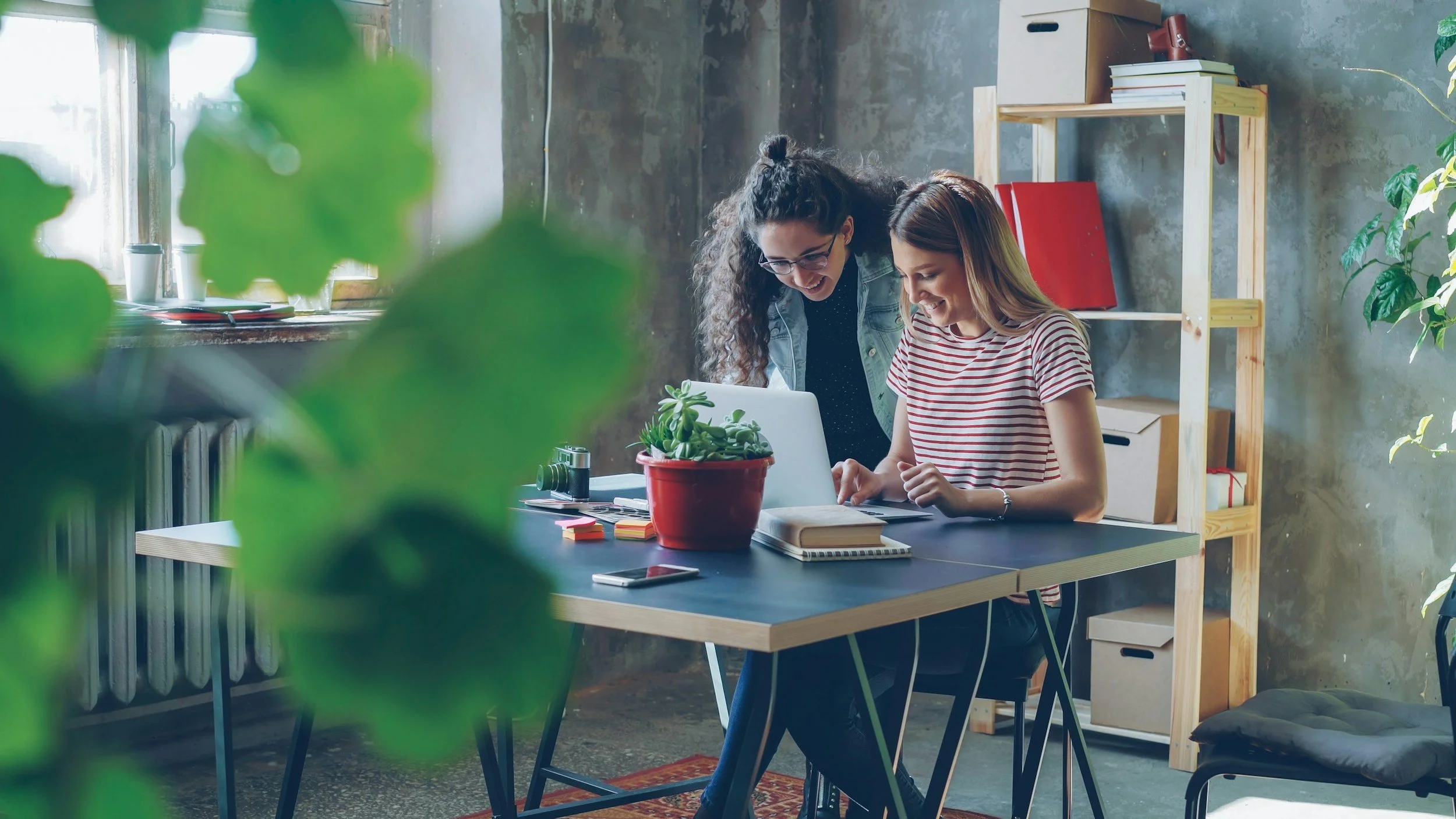 two people working together in front of computer