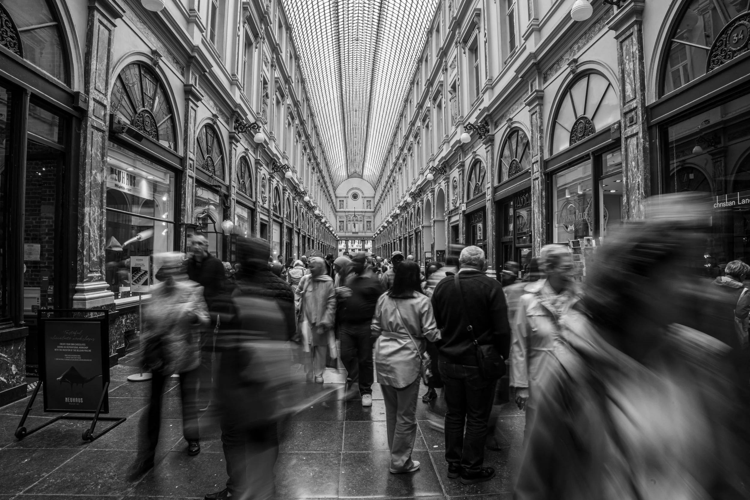 Bruxelles - Blurred footsteps in marble halls, a river of lives flowing under glass skies.