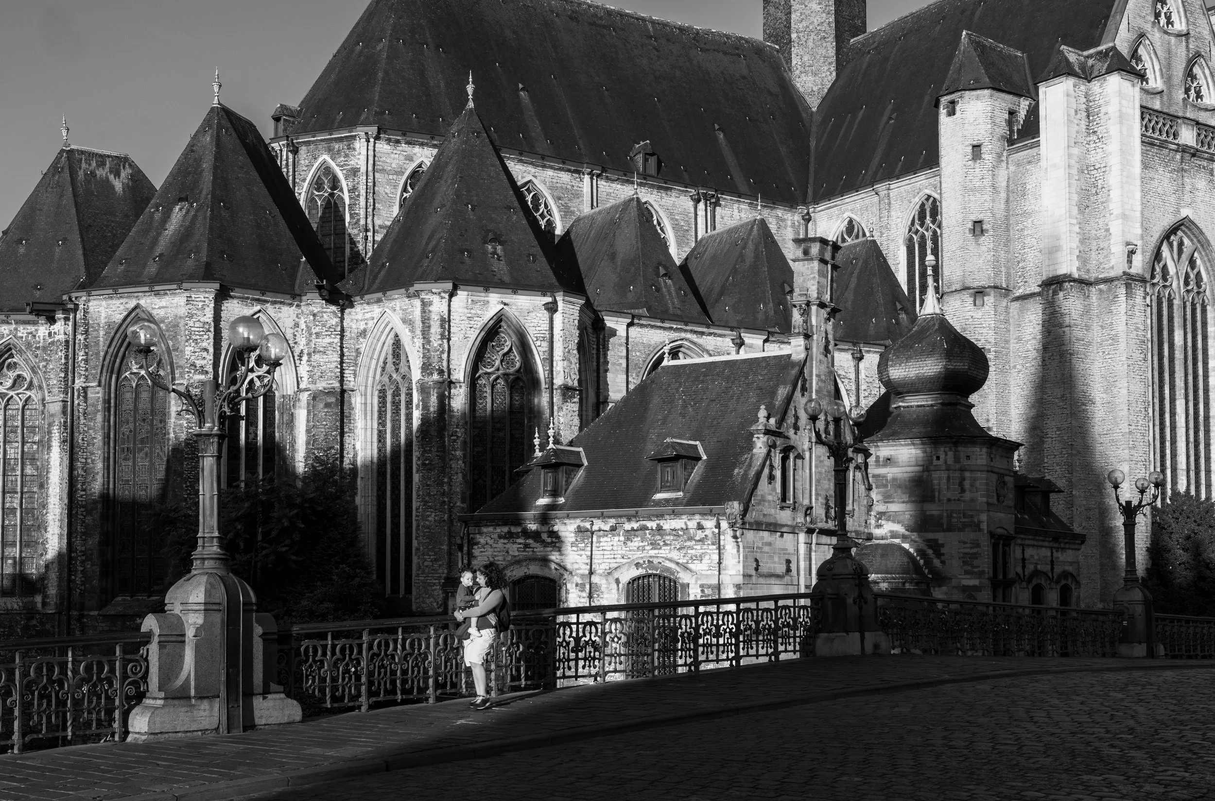 Gent - Gothic walls cradle shadows, while fleeting tenderness glows brighter than centuries carved in stone.
