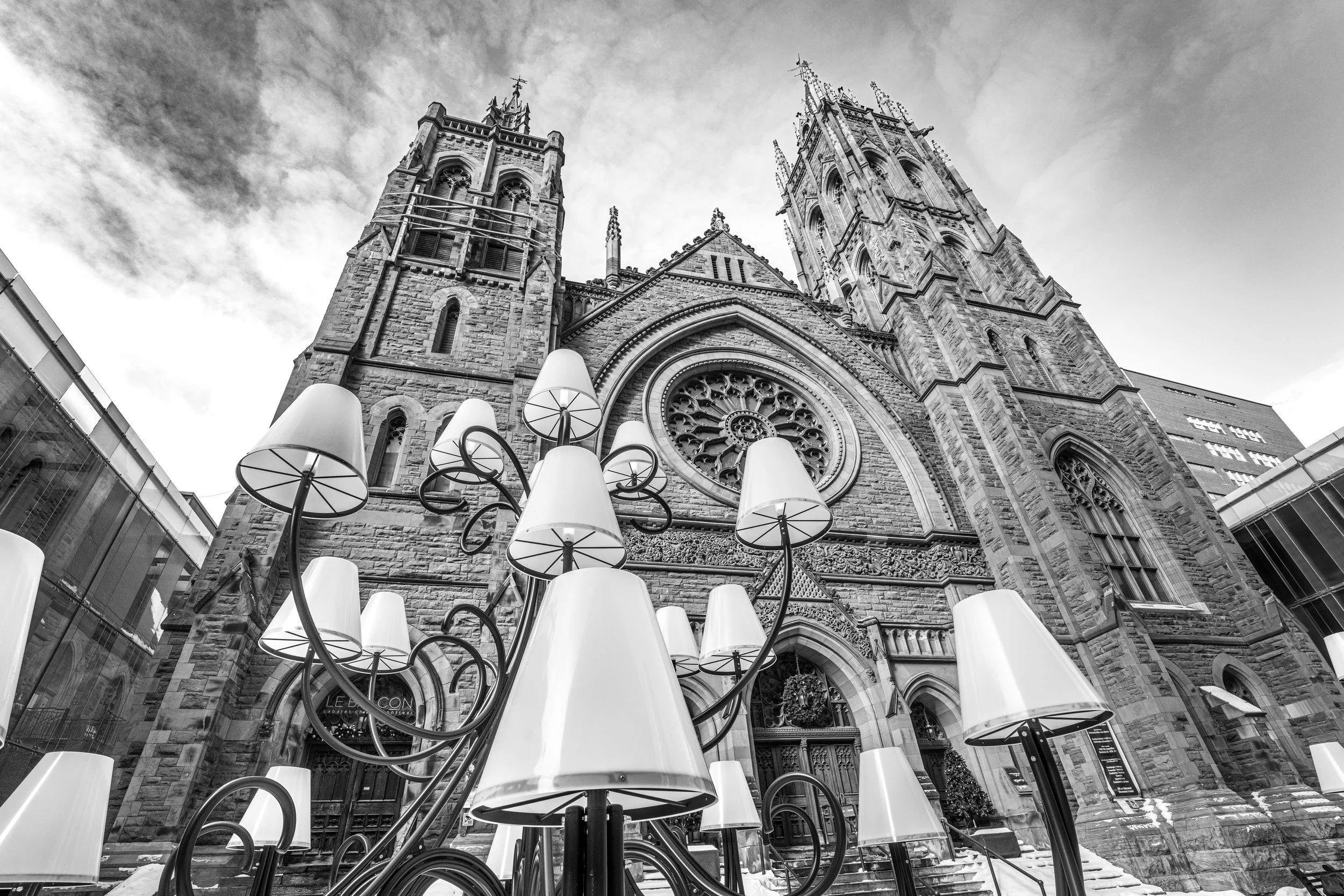 Montréal, Saint James United Church - Gothic stone towers rise, modern lamps below weaving dialogue between faith and city.