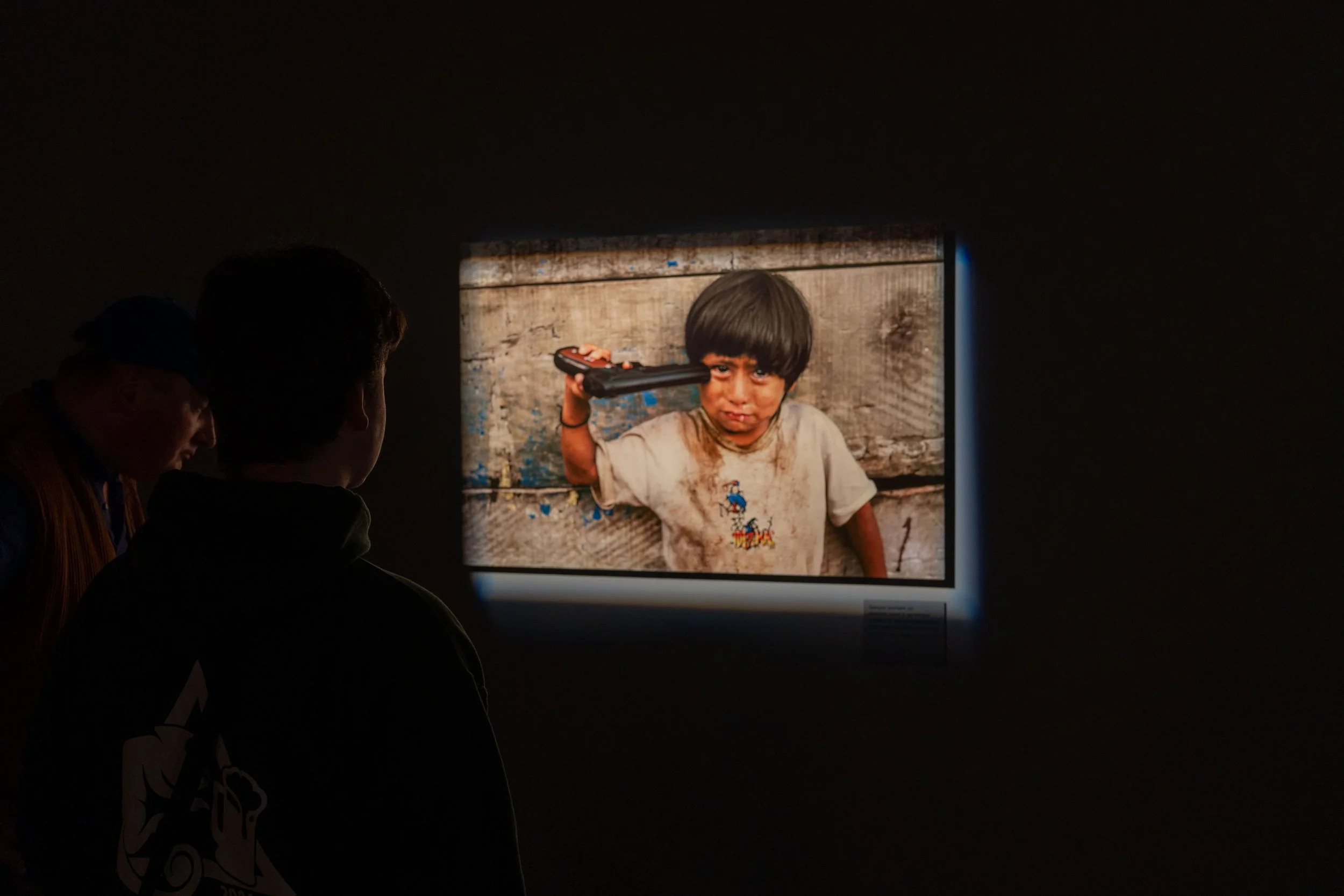 Brussels, Tribute to Steve McCurry - In the museum’s darkness, a boy’s portrait becomes history’s wound, urging memory and justice.