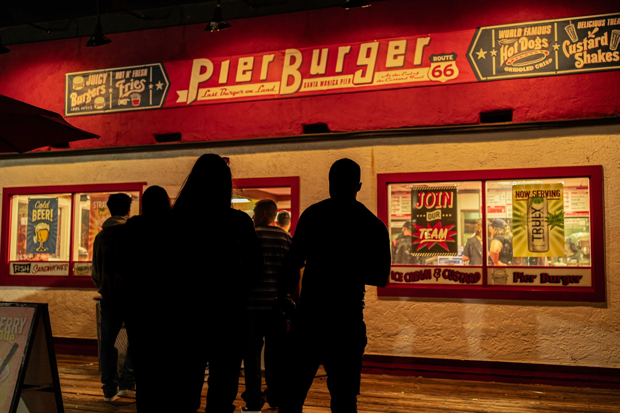 Santa Monica: Under bright signs and warm lights, strangers share the quiet ritual of a late-night burger.