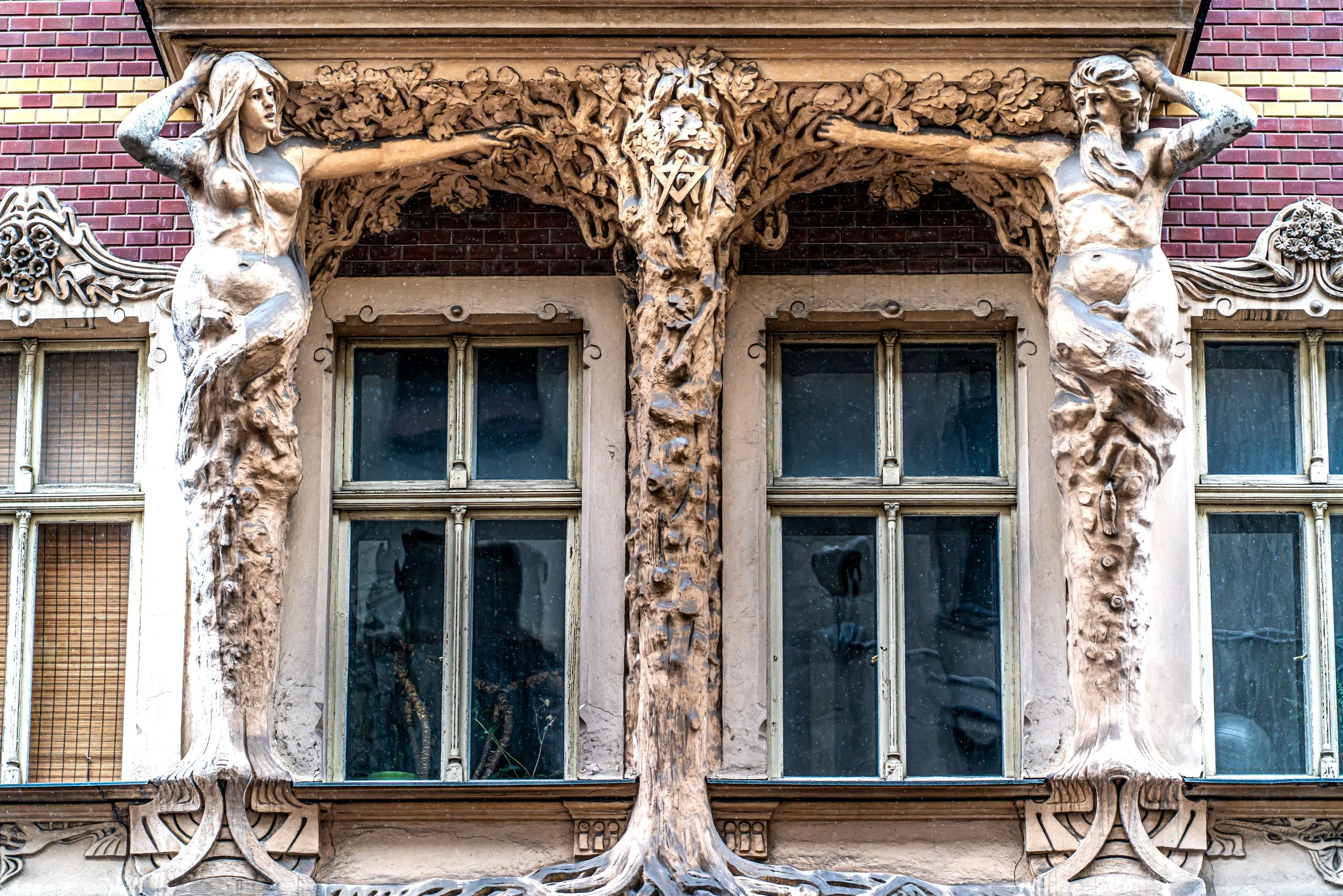 Riga, Art Nouveau facade — Figures entwined with trees, bodies become columns, nature and humanity merging in sculpture.