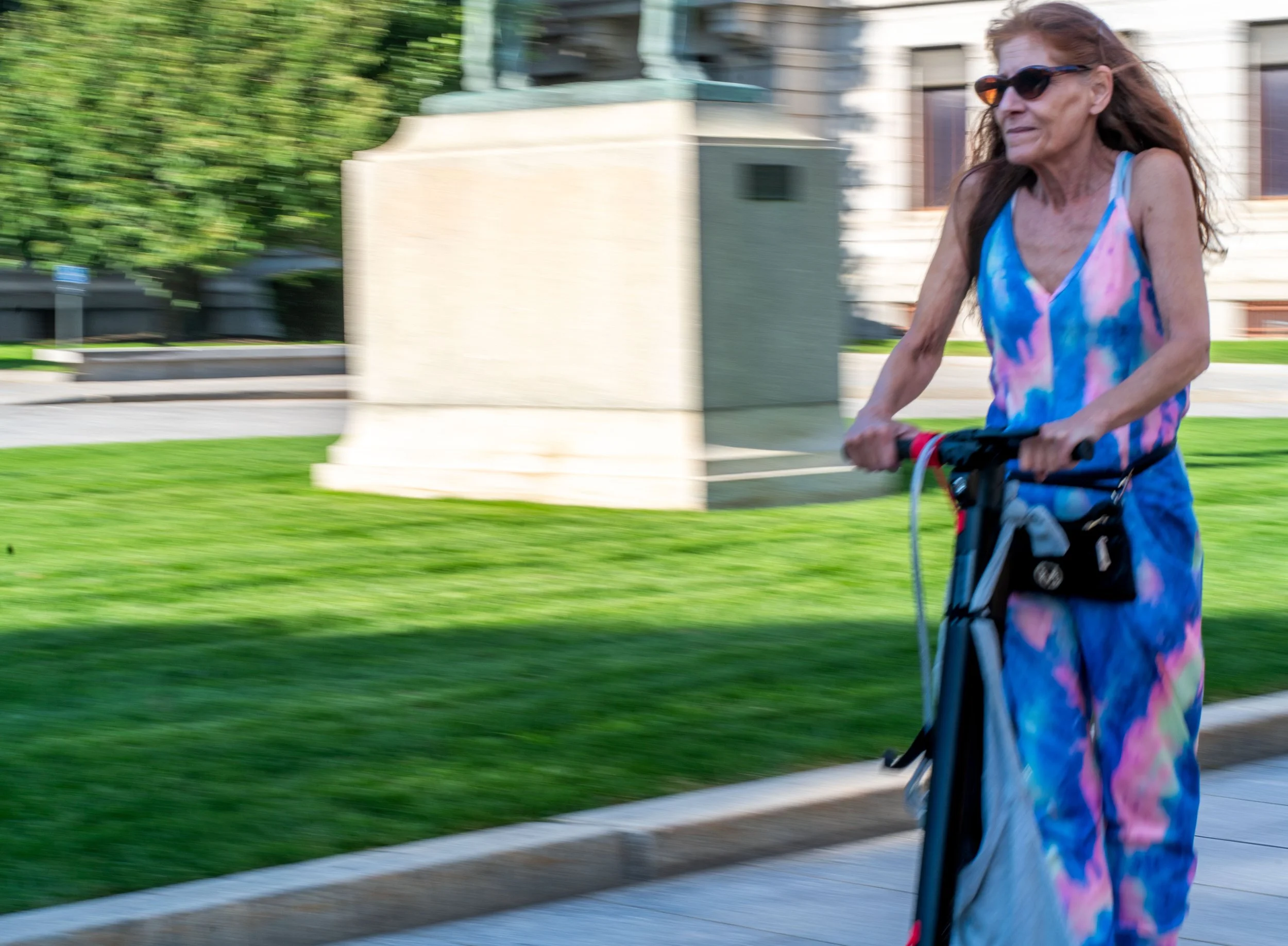 Boston - She glides in colors, sunlight catching her dress, freedom rides on quiet wheels.