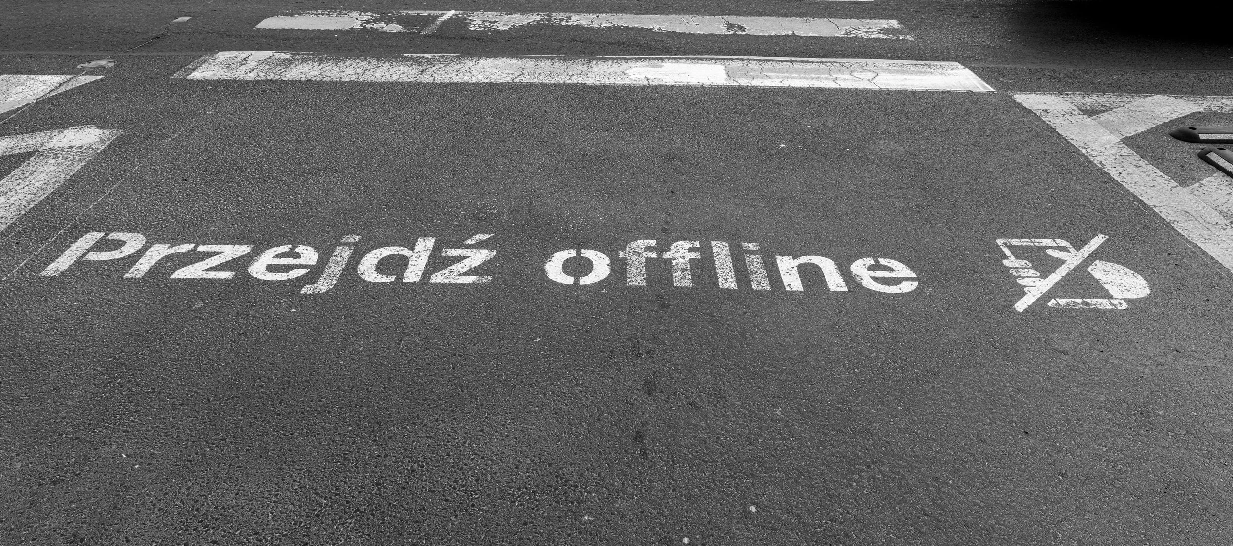 Poznań – On the asphalt, a reminder: look up, disconnect, let the city be your screen.